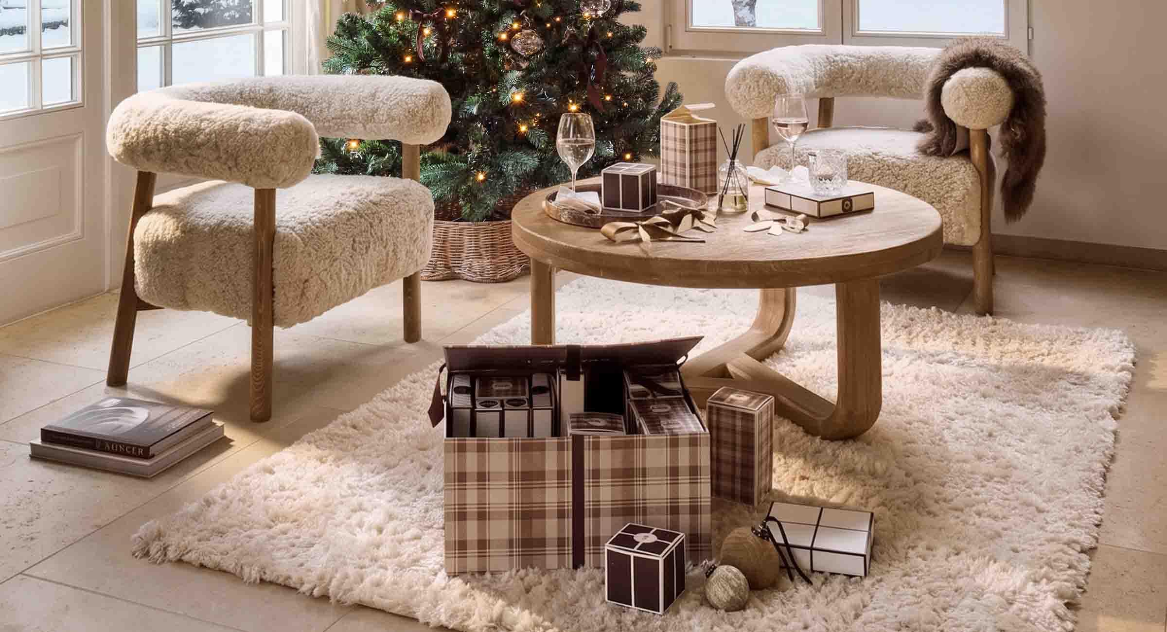 Salon chaleureux avec fauteuils en fausse fourrure crème et table en bois près d'un sapin de Noël décoré