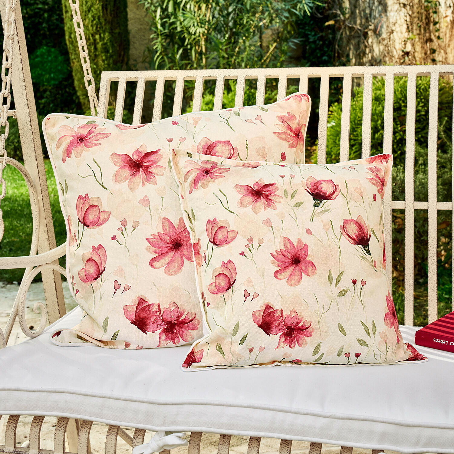 Deux coussins décoratifs à motifs floraux sur une balançoire blanche, tissu coton, motifs roses clairs