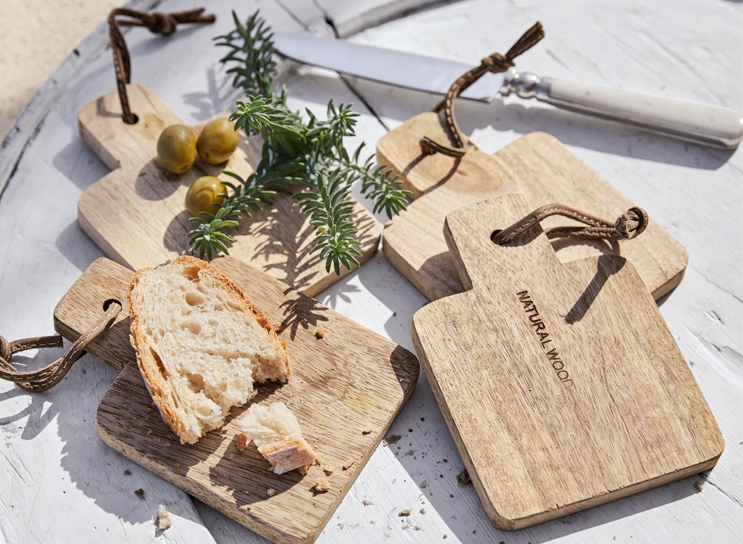 Ensemble de planches à découper en bois naturel avec pain et olives sur table blanche, style méditerranéen