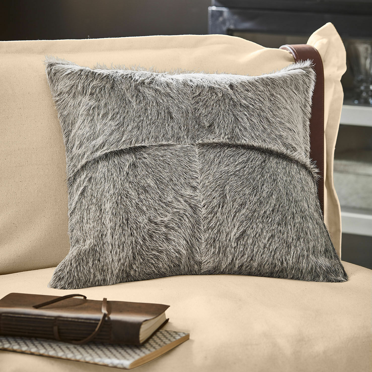 Housse de coussin Nymarion Coussin décoratif gris en matière fourrure sur canapé beige, accessoire élégant pour intérieur