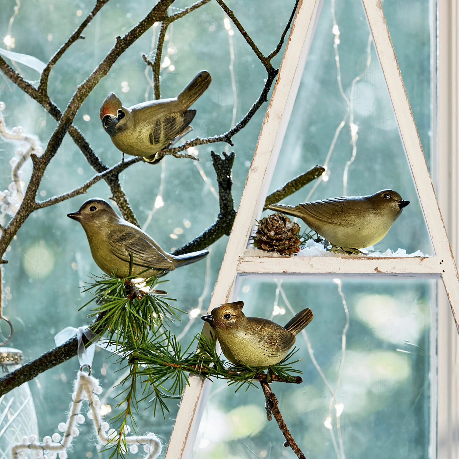 Lot de 4 oiseaux décoratifs Pompaire Oiseaux décoratifs en plastique sur branches et cadre en bois blanc près d'une fenêtre avec guirlandes LED