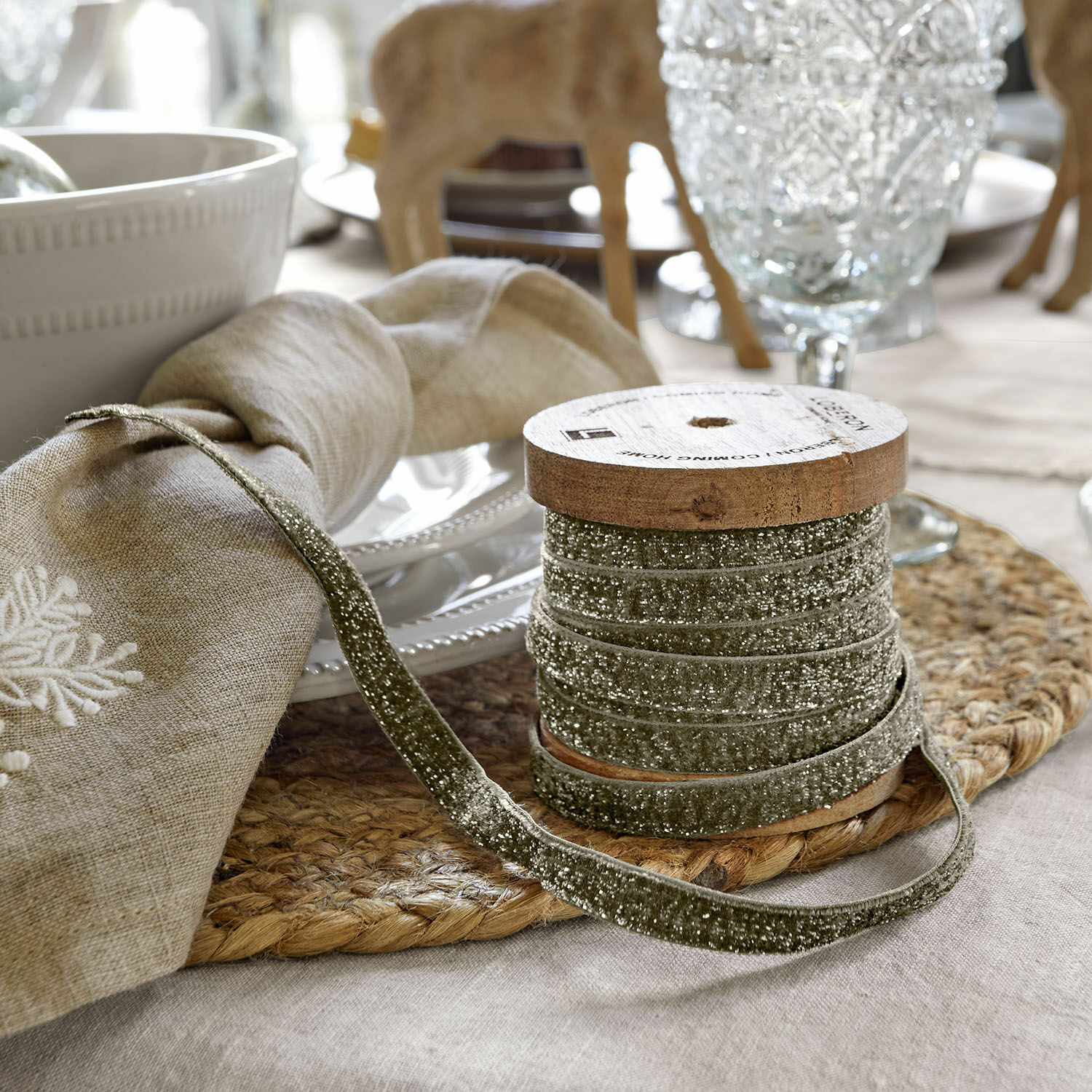 Ruban de velours Ulvane Ruban en velours gris sur bobine en bois sur une table rustique avec décorations de table