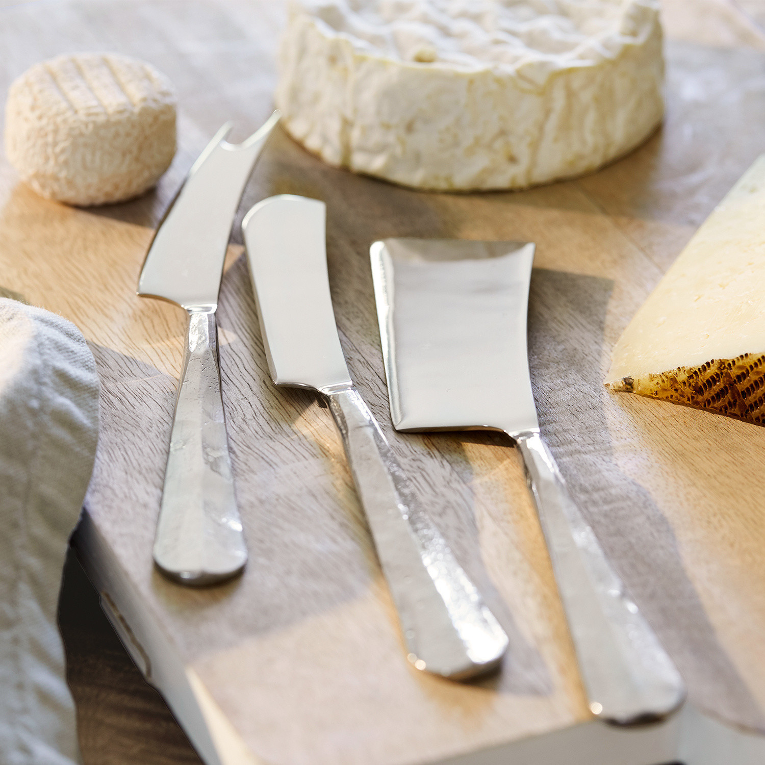 Lot de 3 couverts à fromage Mondevert Ensemble de trois couteaux à fromage en acier inoxydable sur planche en bois avec fromages variés