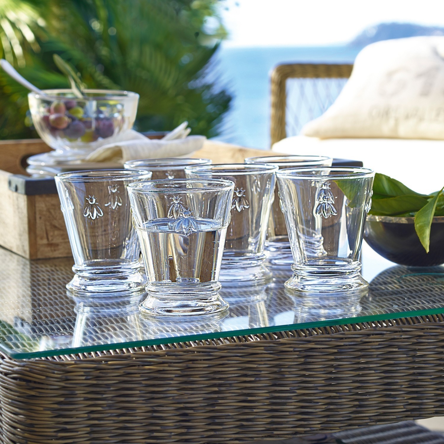 Lot de 6 verres à eau Abeille Ensemble de six verres en verre transparent avec motif d'abeille, posés sur une table en verre en extérieur