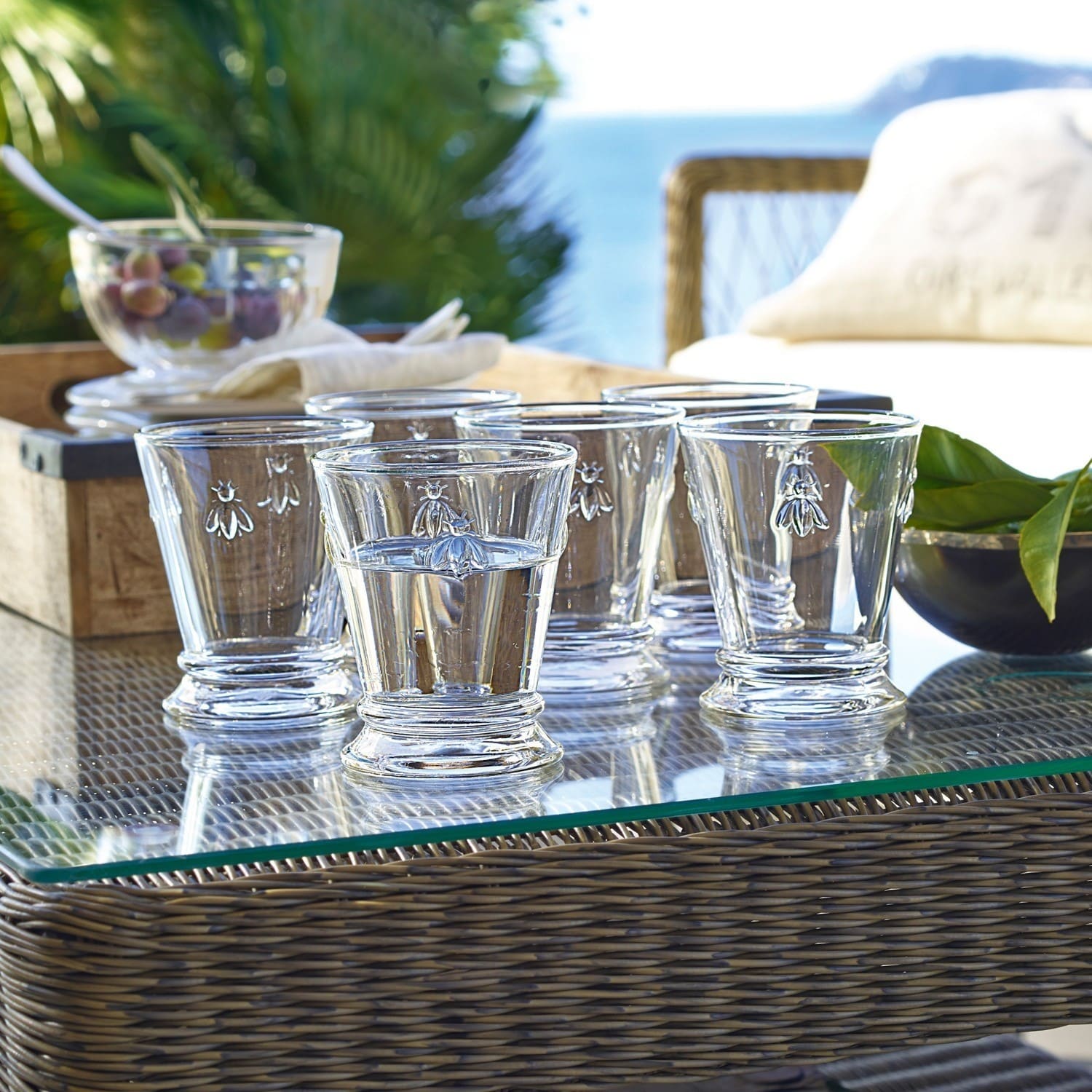 Lot de 6 verres à eau Abeille Ensemble de six verres en verre transparent avec motif d'abeille, posés sur une table en verre en extérieur