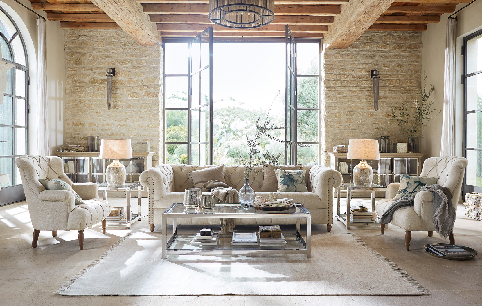 Salon classique élégant avec canapé beige, fauteuils, table basse en verre et matériaux naturels