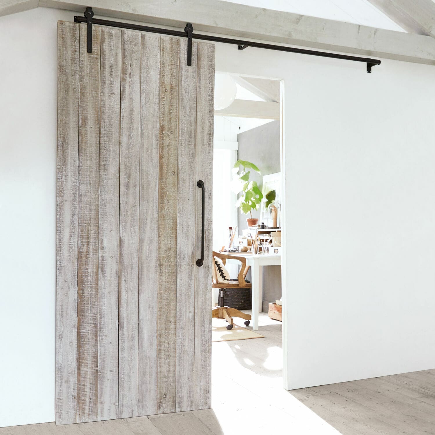 Porte coulissante Sunnydale Porte coulissante en bois couleur chêne blanchi avec poignée métallique dans un intérieur lumineux moderne