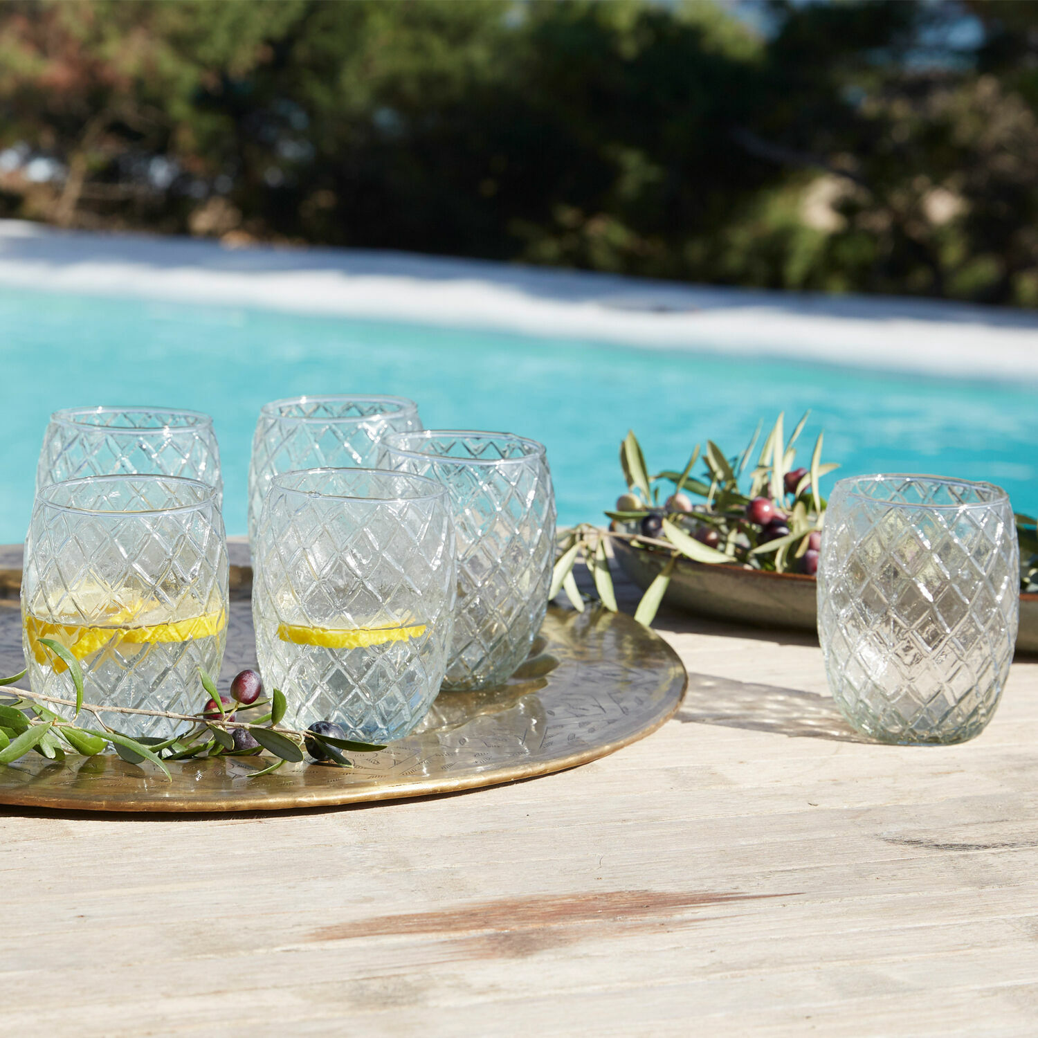 Lot de 6 verres Corrofin Verres en verre transparent à motif diamant sur un plateau doré au bord de la piscine
