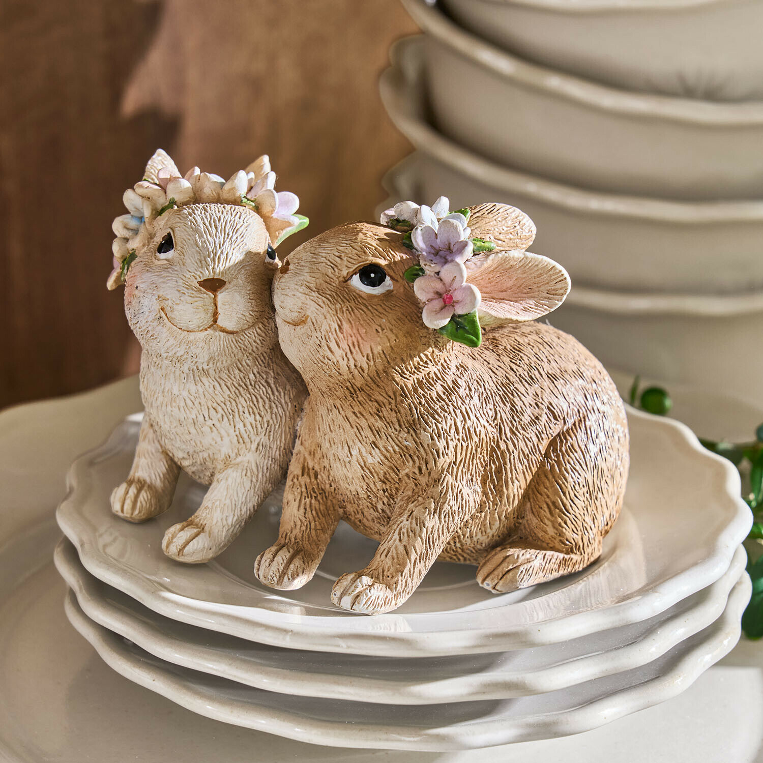 Lapins Willowmare Deux figurines de lapins en céramique beige et blanc avec couronnes de fleurs sur des assiettes blanches