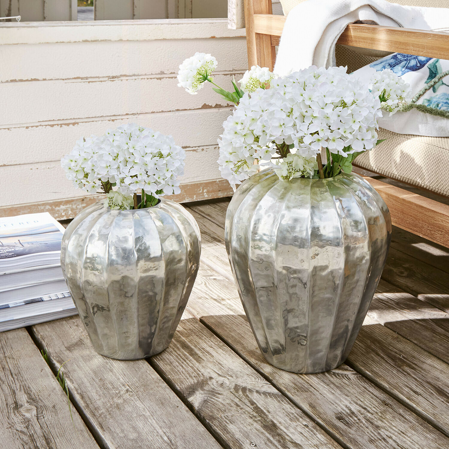 Lot de 2 vases Lévronne Deux vases en métal argenté avec des fleurs blanches sur une terrasse en bois, décoration intérieure