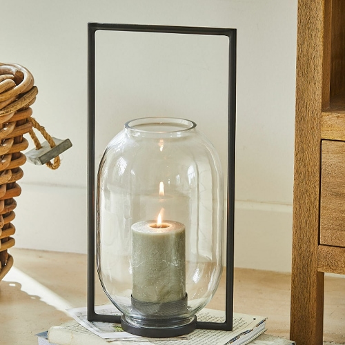 Lanterne en verre avec cadre métallique noir et bougie verte pour décoration intérieure