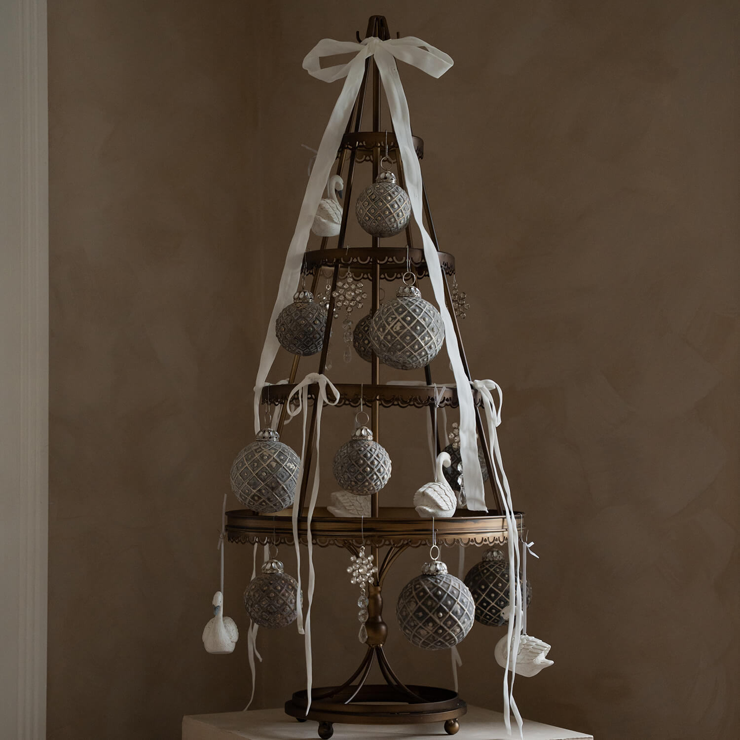 Sapin décoratif en métal avec boules grises et rubans blancs dans un style vintage élégant