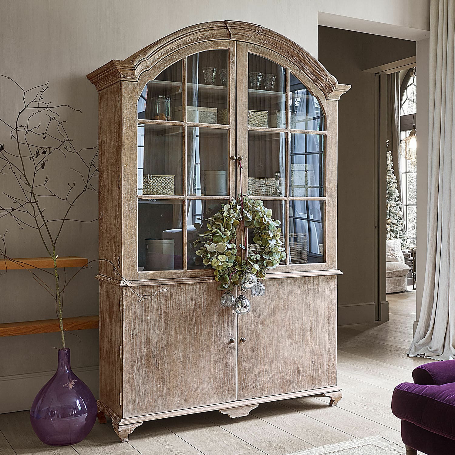 Buffet Périmonde Vitrine rustique en bois avec portes vitrées et couronne décorative dans un salon élégant