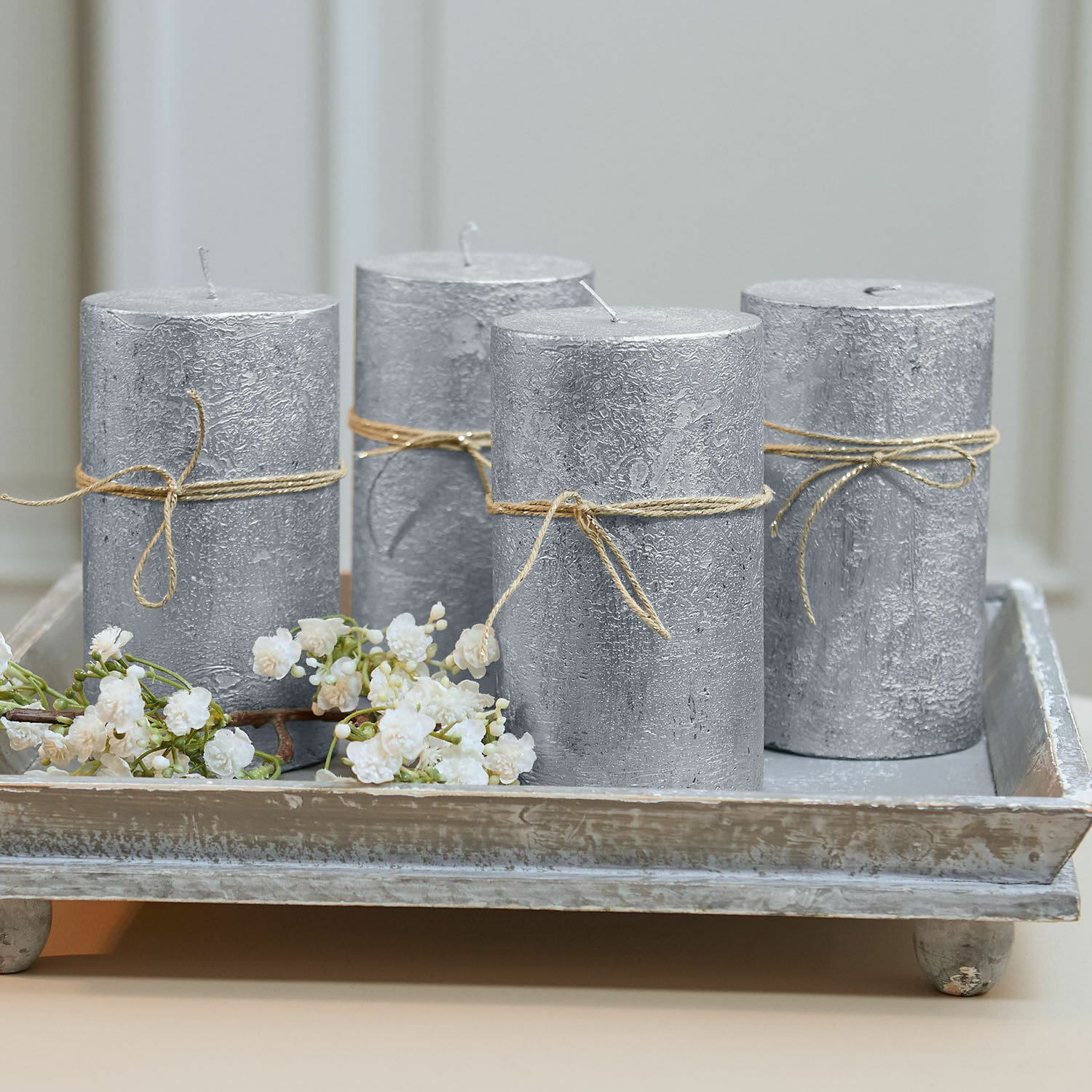Lot de 4 bougies Braga Ensemble de quatre bougies argentées texturées avec cordelette sur un plateau en bois décoratif