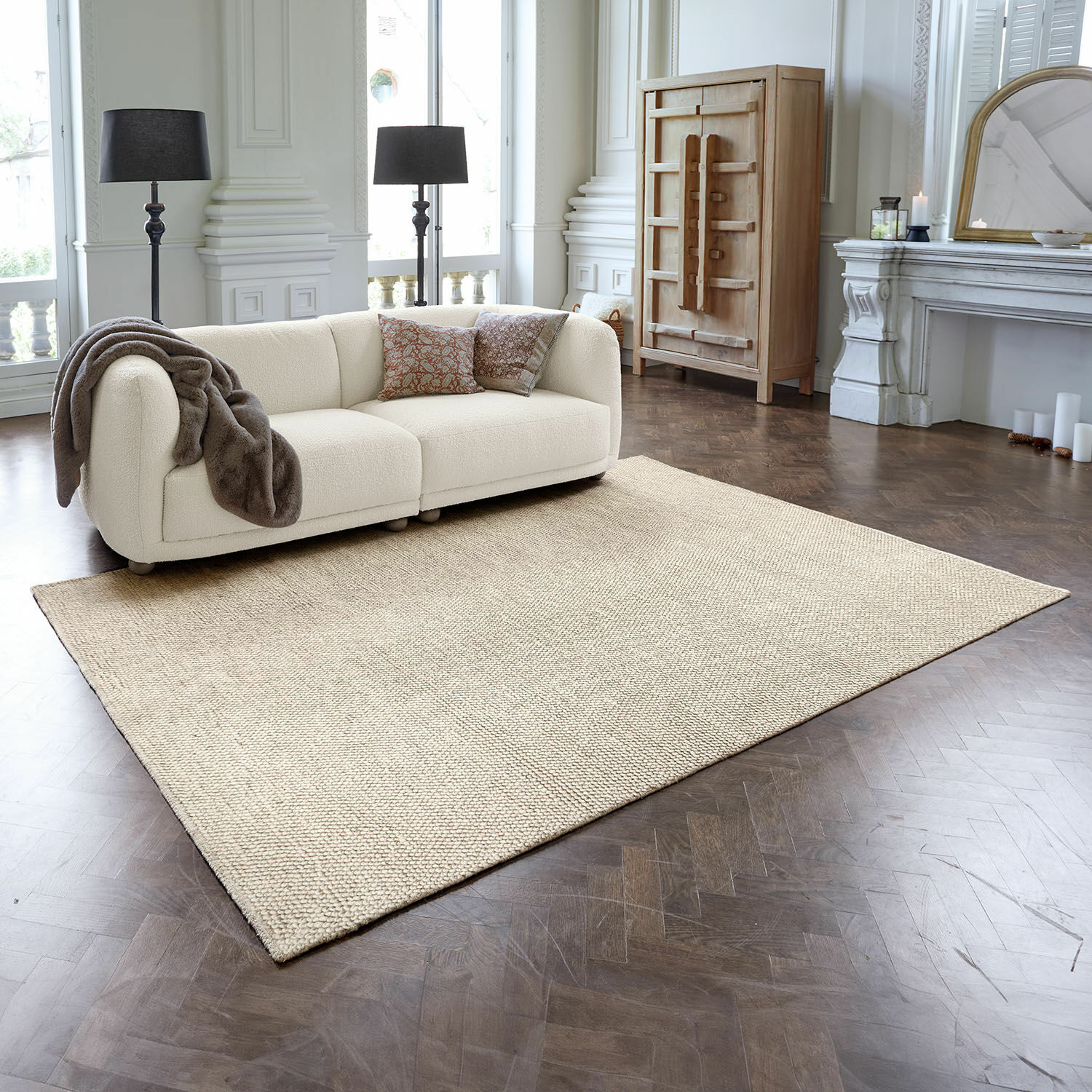 Tapis Coleman Tapis beige en matériau naturel sur parquet foncé dans un salon élégant avec canapé crème
