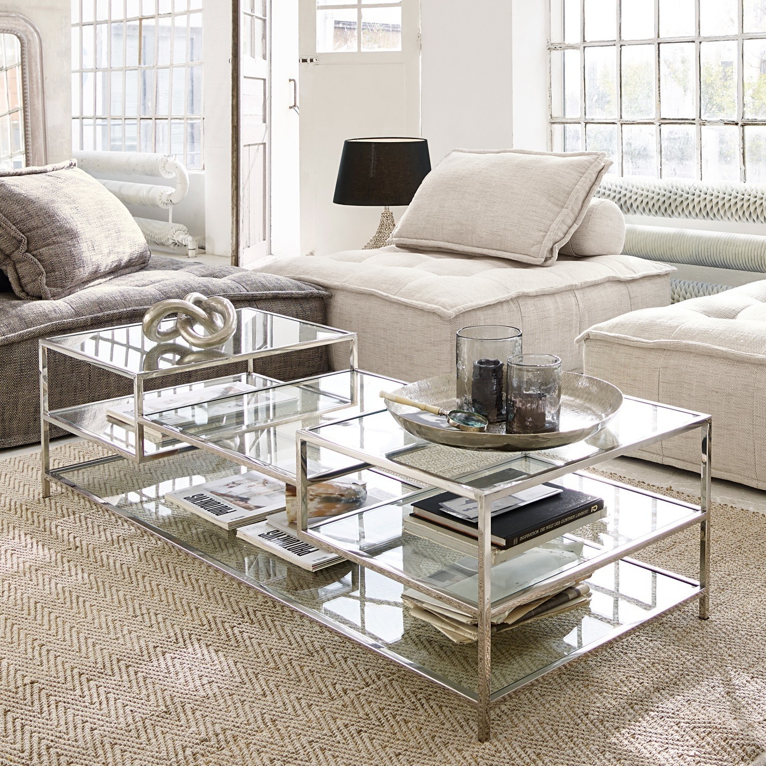 Table basse Byllis Table basse moderne en verre et métal argenté sur tapis beige dans un salon lumineux