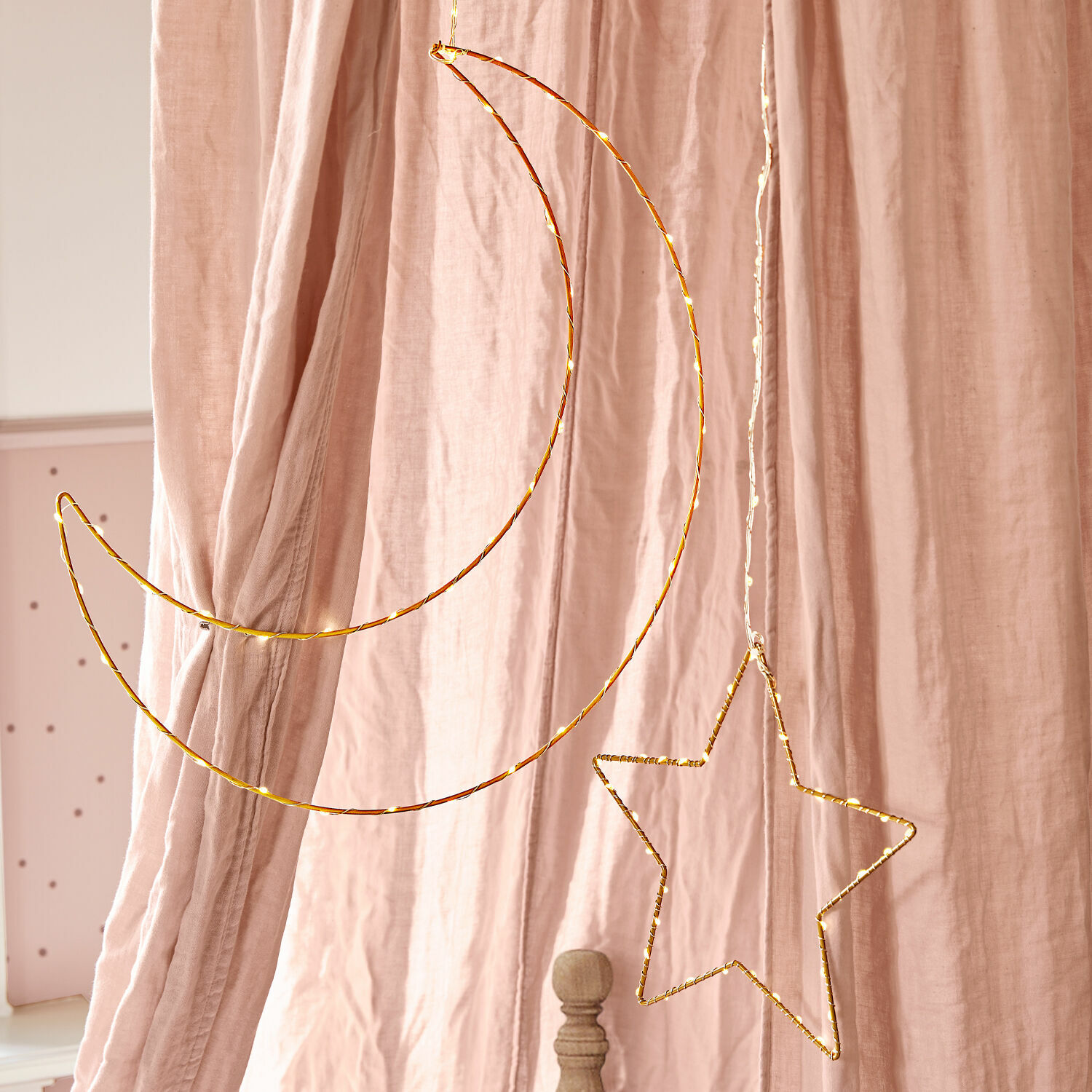 Lot de 2 décorations lumineuses Padden Décoration suspendue en fil métallique doré en forme de lune et d'étoile devant des rideaux roses