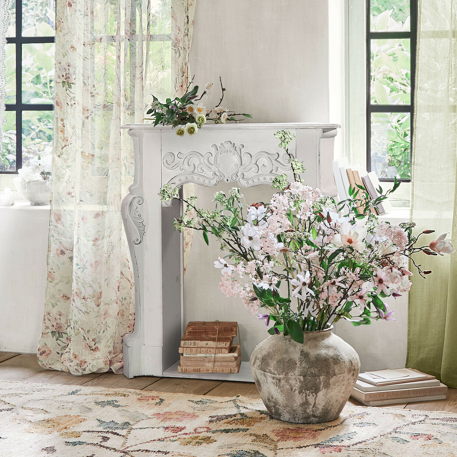 Console de cheminée Emporia Grand vase en céramique grise avec bouquet de fleurs roses et blanches dans un salon lumineux avec cheminée décorative