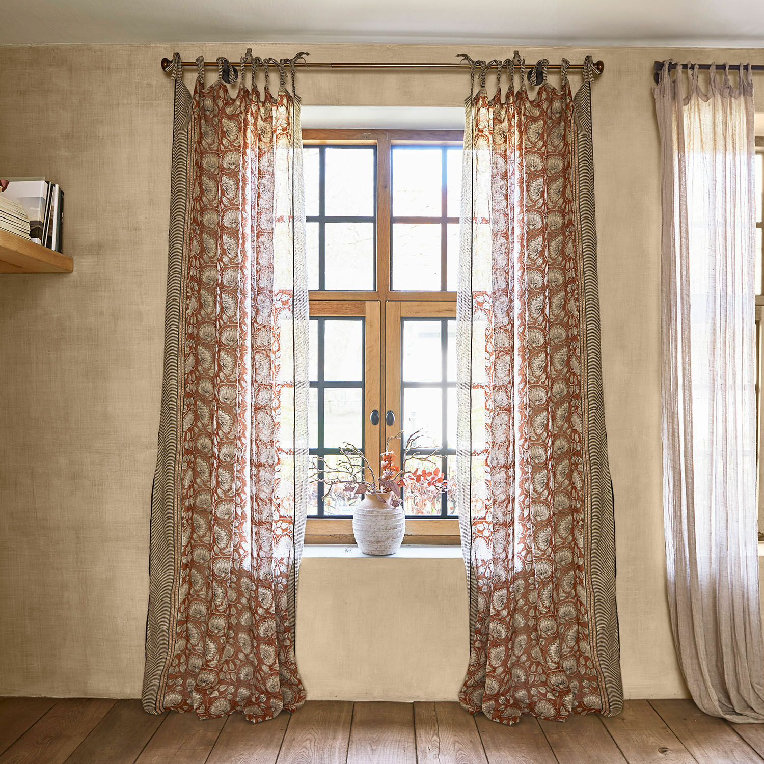 Voilage Lemisto Rideaux transparents à motif floral dans des tons chauds sur une fenêtre à cadre en bois