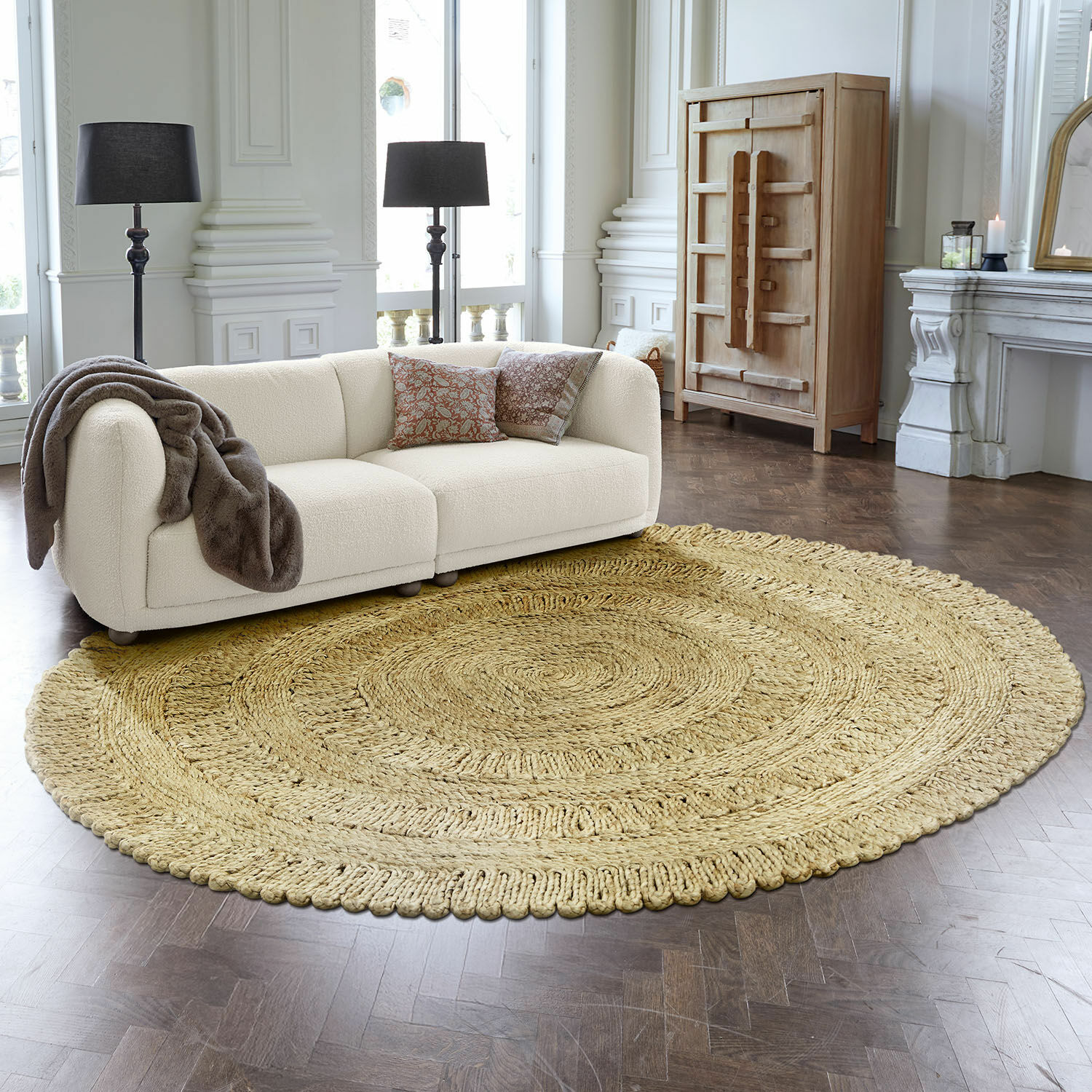 Tapis Arendel Tapis rond en matériau naturel beige dans un salon moderne avec canapé blanc et lampes noires