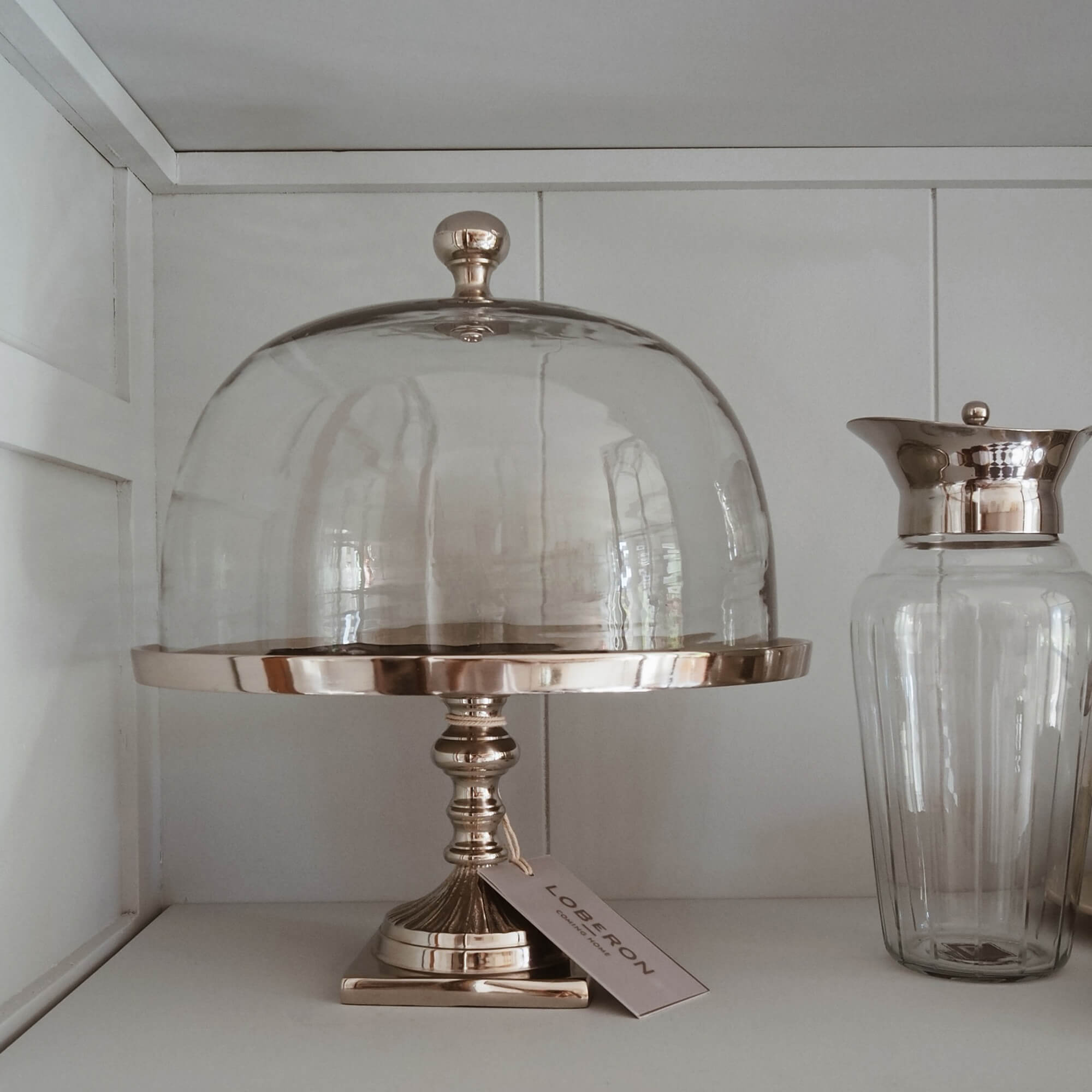 Cloche en verre sur pied en métal doré pour présenter gâteaux et desserts dans un style slow living