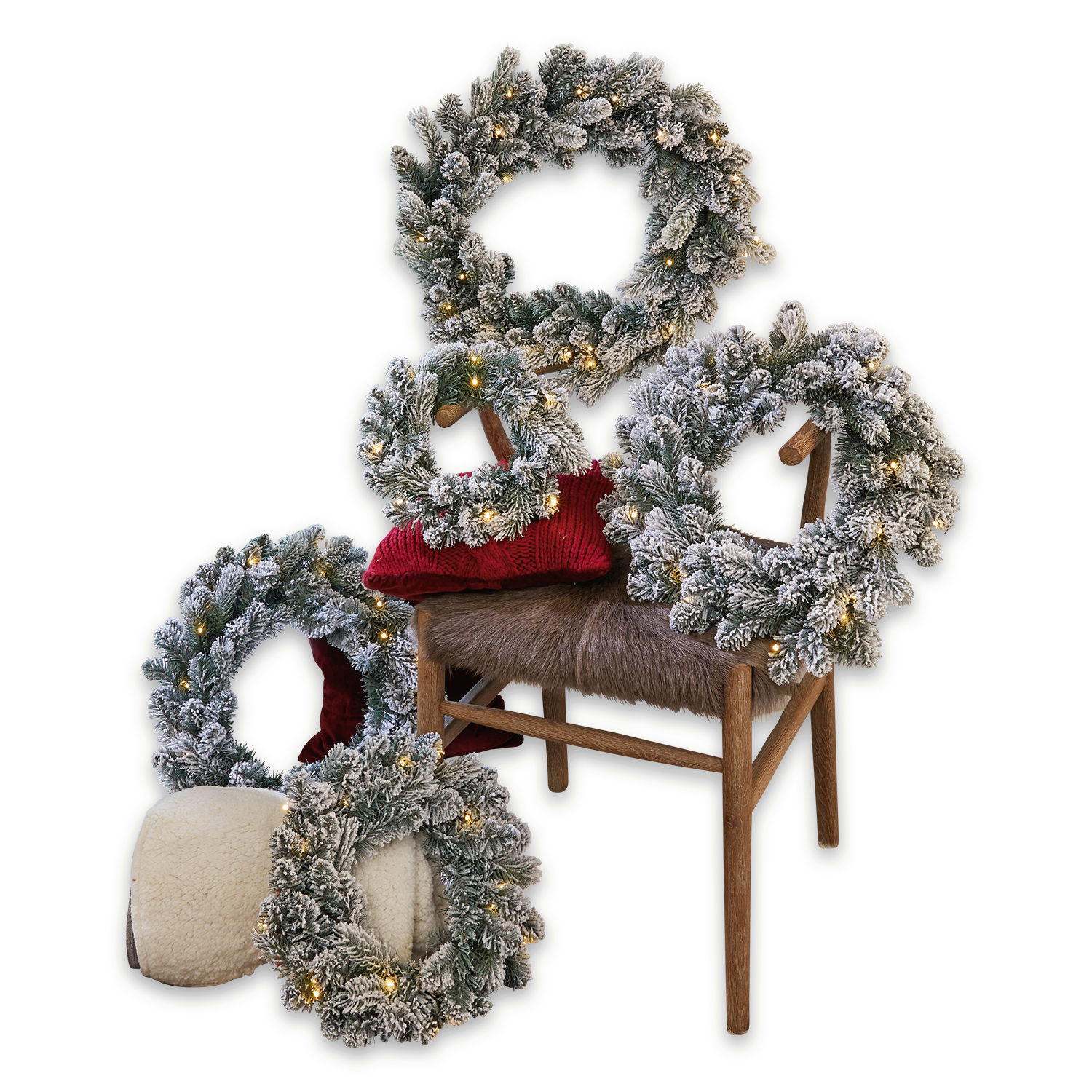 Lot de 5 couronnes Ellaria Ensemble de cinq couronnes de Noël avec branches enneigées et lumières LED chaudes sur chaise et coussin
