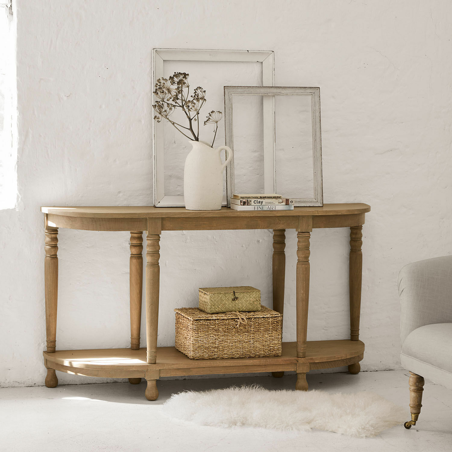 Console Brookdale Console en bois naturel avec cadres décoratifs et vase avec fleurs séchées dans un intérieur clair