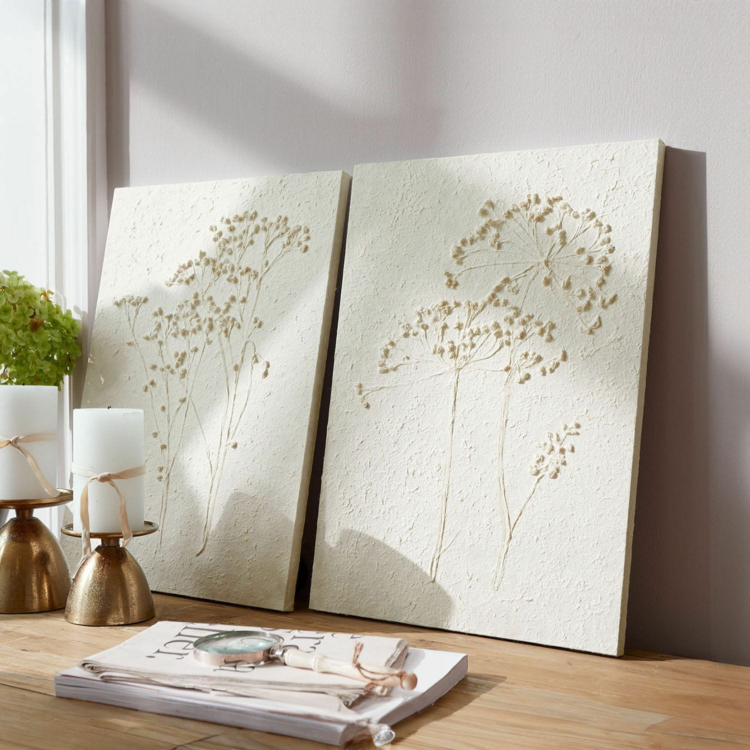 Lot de 2 tableaux Tiloren Panneaux décoratifs muraux crème avec relief floral posés sur une table en bois clair