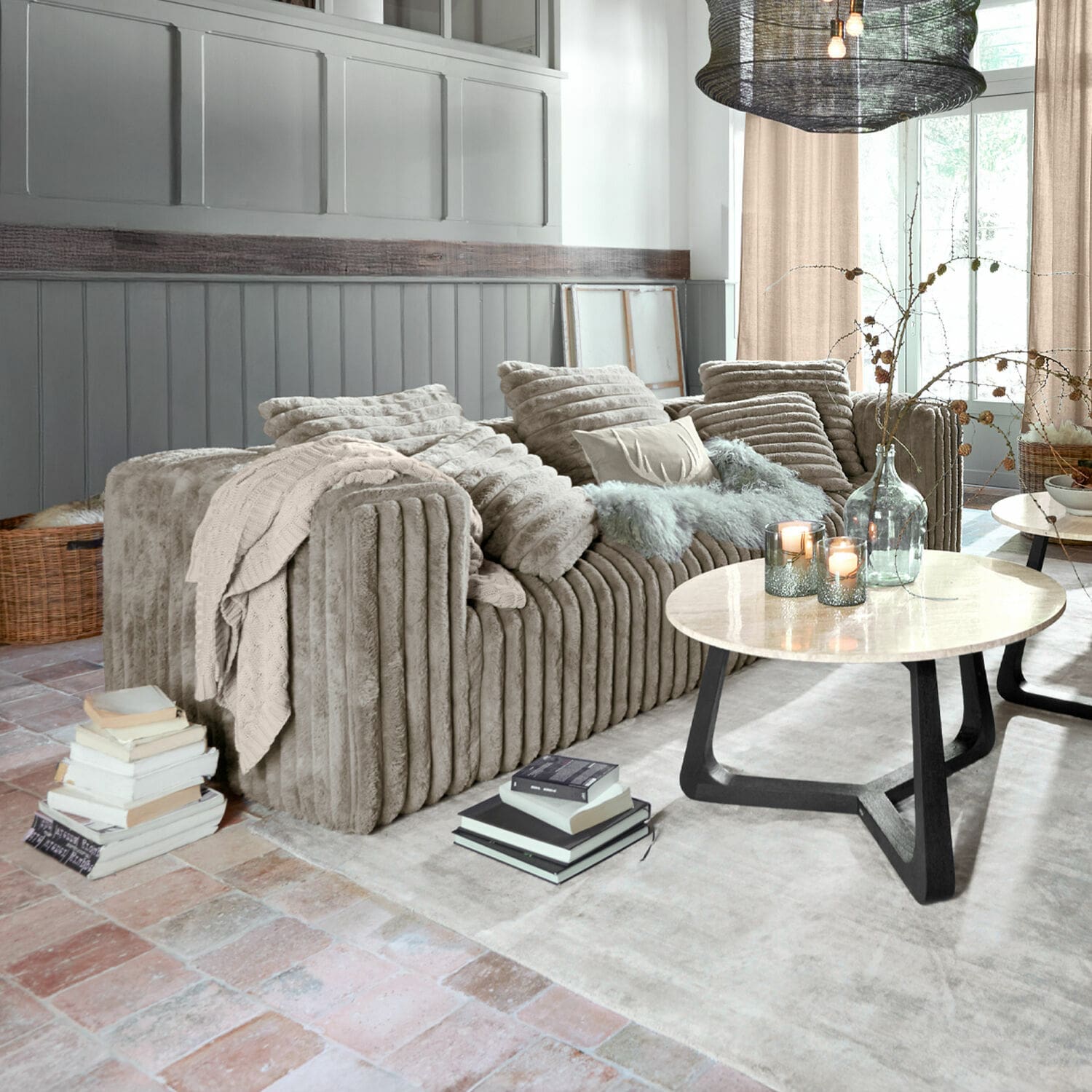 Canapé Roucemont Canapé beige en velours doux avec coussins et plaid dans un salon moderne avec table basse en marbre