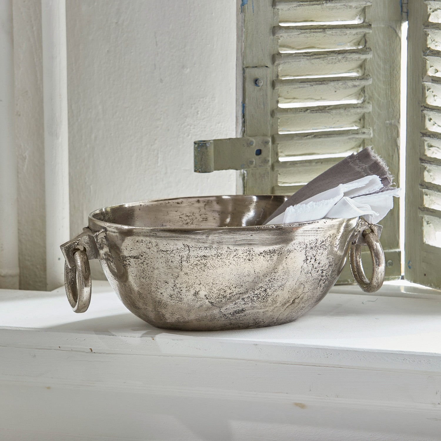 Coupe Starlett Bol décoratif en métal argenté avec poignées et serviettes en lin sur le rebord de la fenêtre