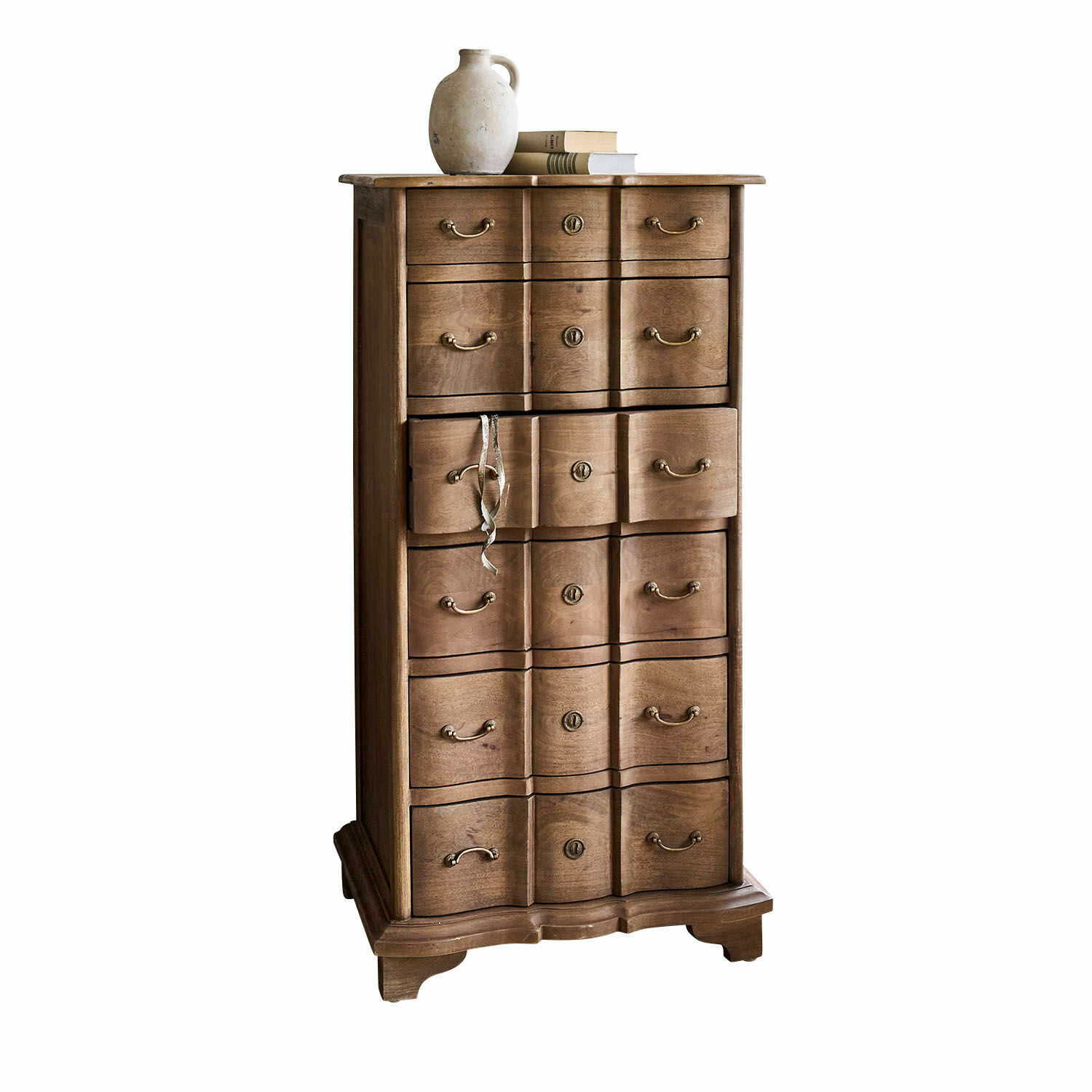 Chiffonnier Aiguillon Commode haute en bois naturel avec plusieurs tiroirs et une cruche en céramique posée sur des livres