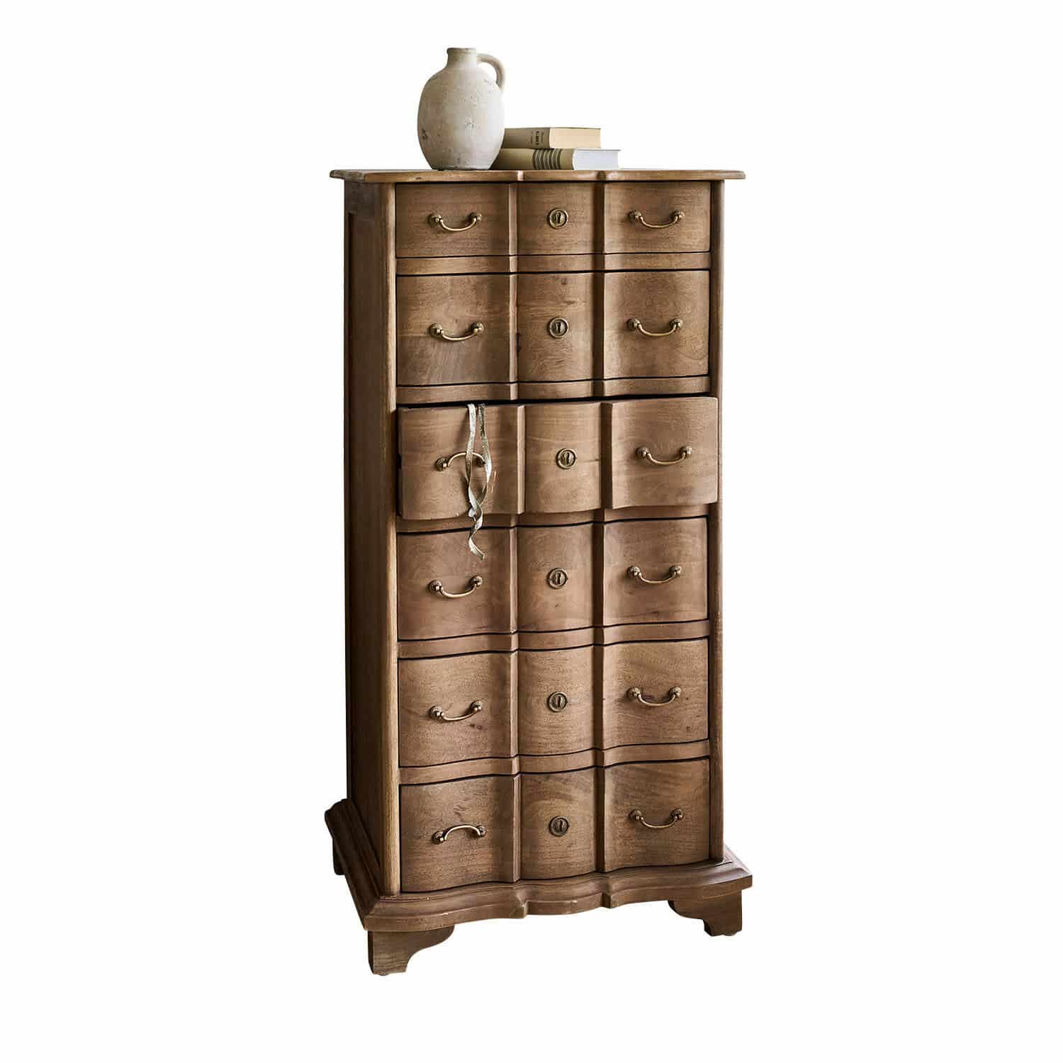 Chiffonnier Aiguillon Commode haute en bois naturel avec plusieurs tiroirs et une cruche en céramique posée sur des livres