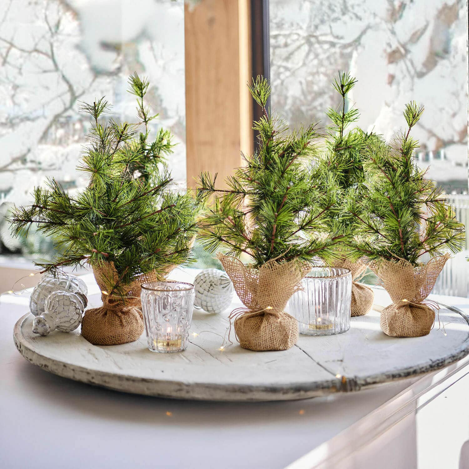 Lot de 4 sapins décoratifs Millies Petits sapins décoratifs en toile de jute sur un plateau blanc avec bougies et décorations de Noël
