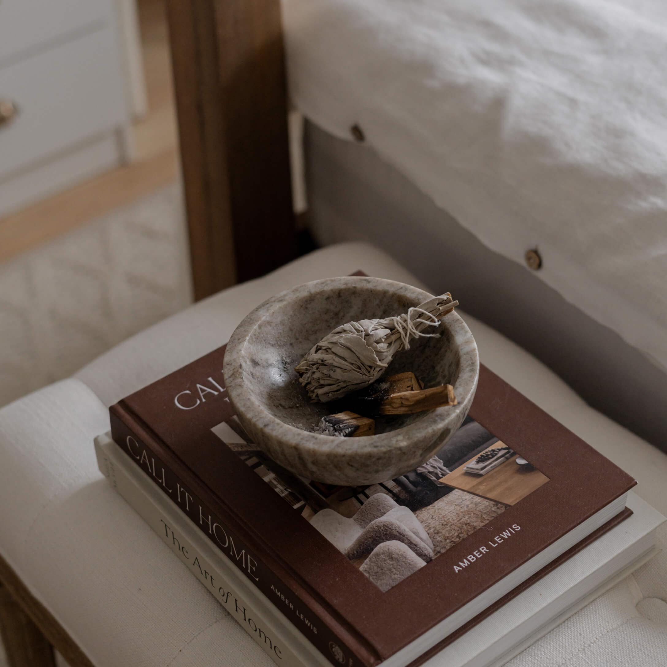 Bol en pierre grise avec des herbes séchées posé sur des livres de décoration intérieure