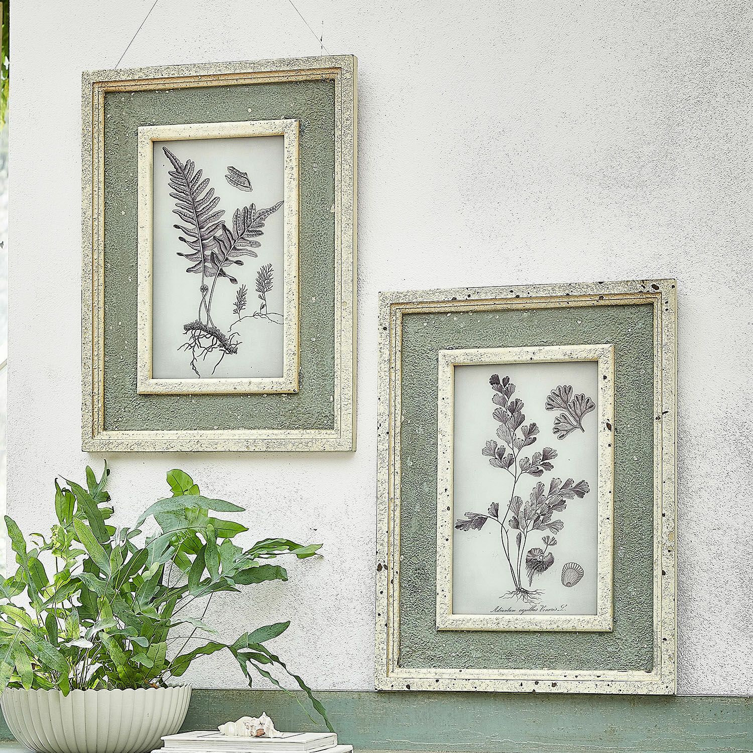 Lot de 2 tableaux Cerilav Deux cadres muraux verts avec illustrations botaniques et texture sur mur blanc style vintage