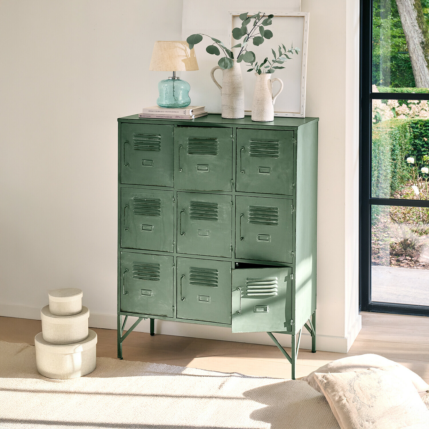 Armoire Urillac Armoire métallique verte à neuf portes avec décorations sur le dessus dans un intérieur lumineux