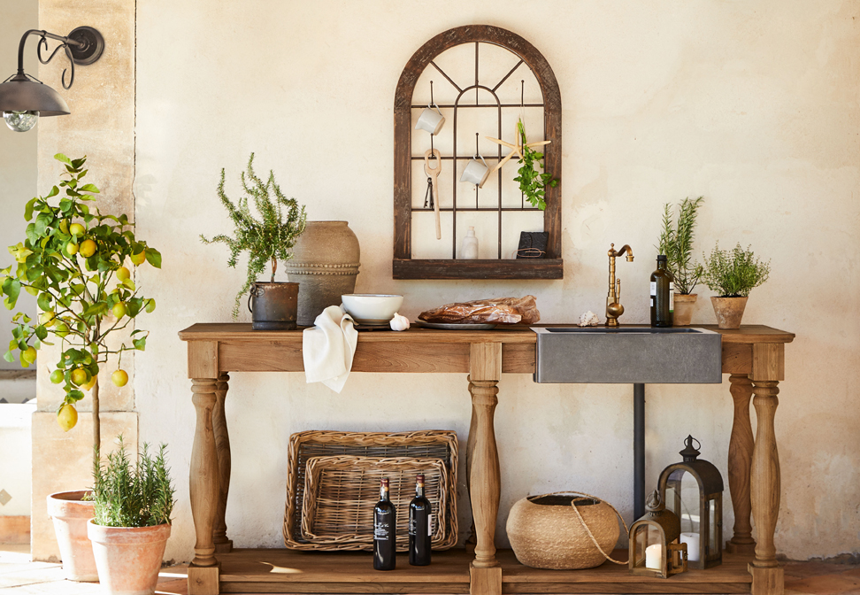 Table en bois avec évier en béton et robinet en cuivre style méditerranéen avec plantes et décorations