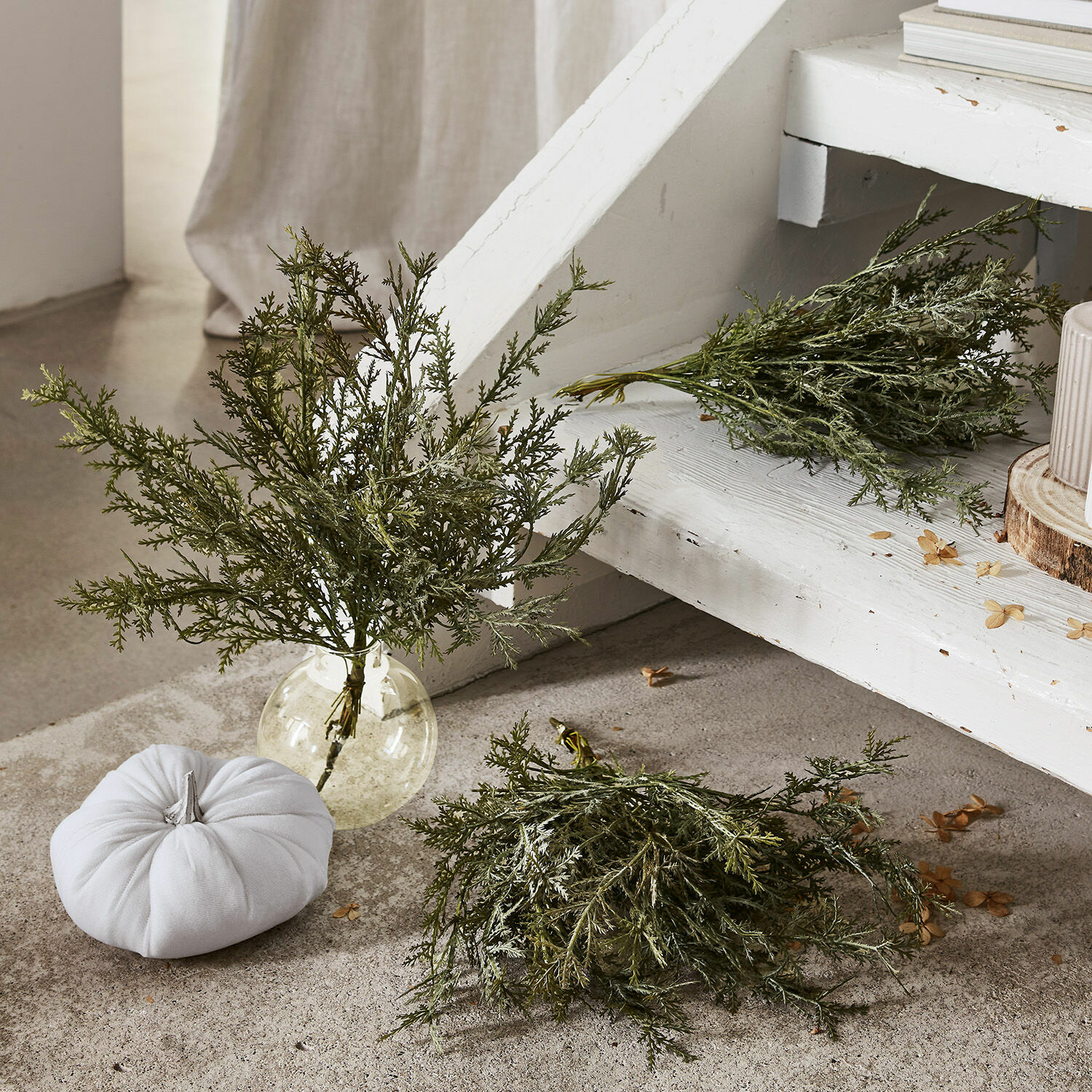 Lot de 3 plantes décoratives Emmet Branches vertes décoratives dans un vase en verre transparent sur fond clair avec une citrouille blanche