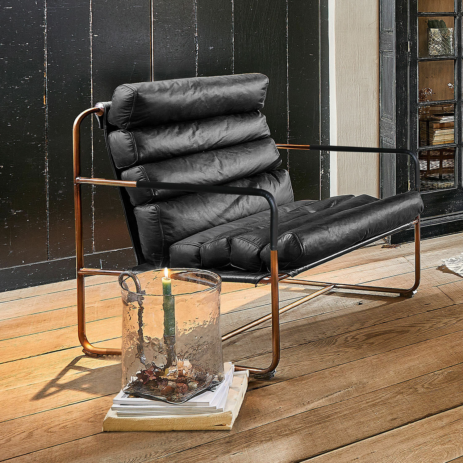 Fauteuil Jelvano Fauteuil en cuir noir avec cadre en cuivre sur parquet en bois dans un intérieur moderne
