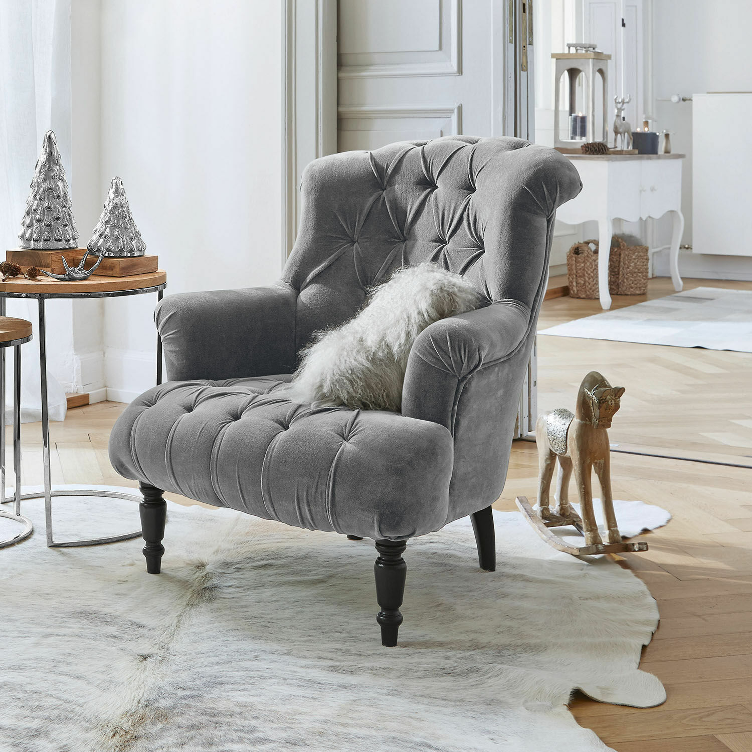 Fauteuil Parranquet Fauteuil gris en velours capitonné avec pieds en bois noir dans un salon lumineux décoré avec style