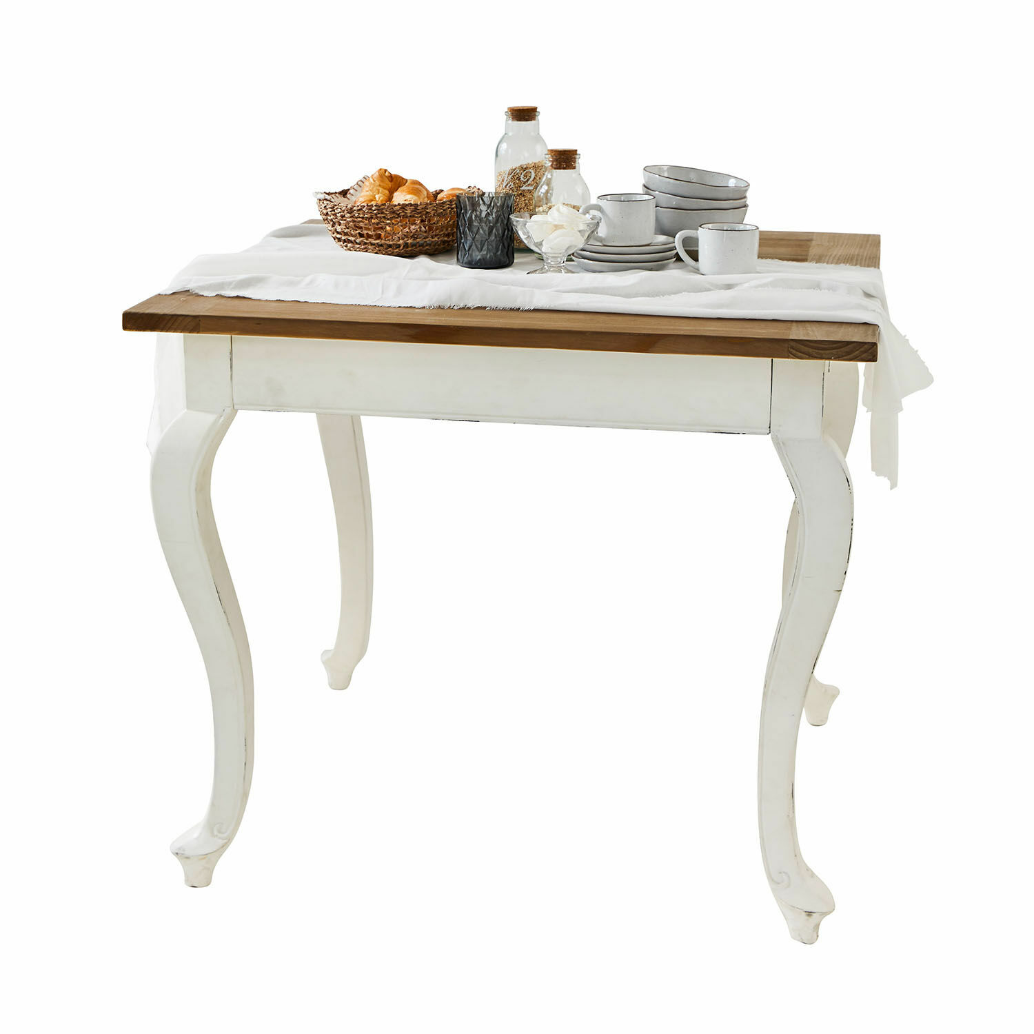 Table Plaish Table en bois avec pieds blancs et plateau marron, décorée de vaisselle et panier de pain