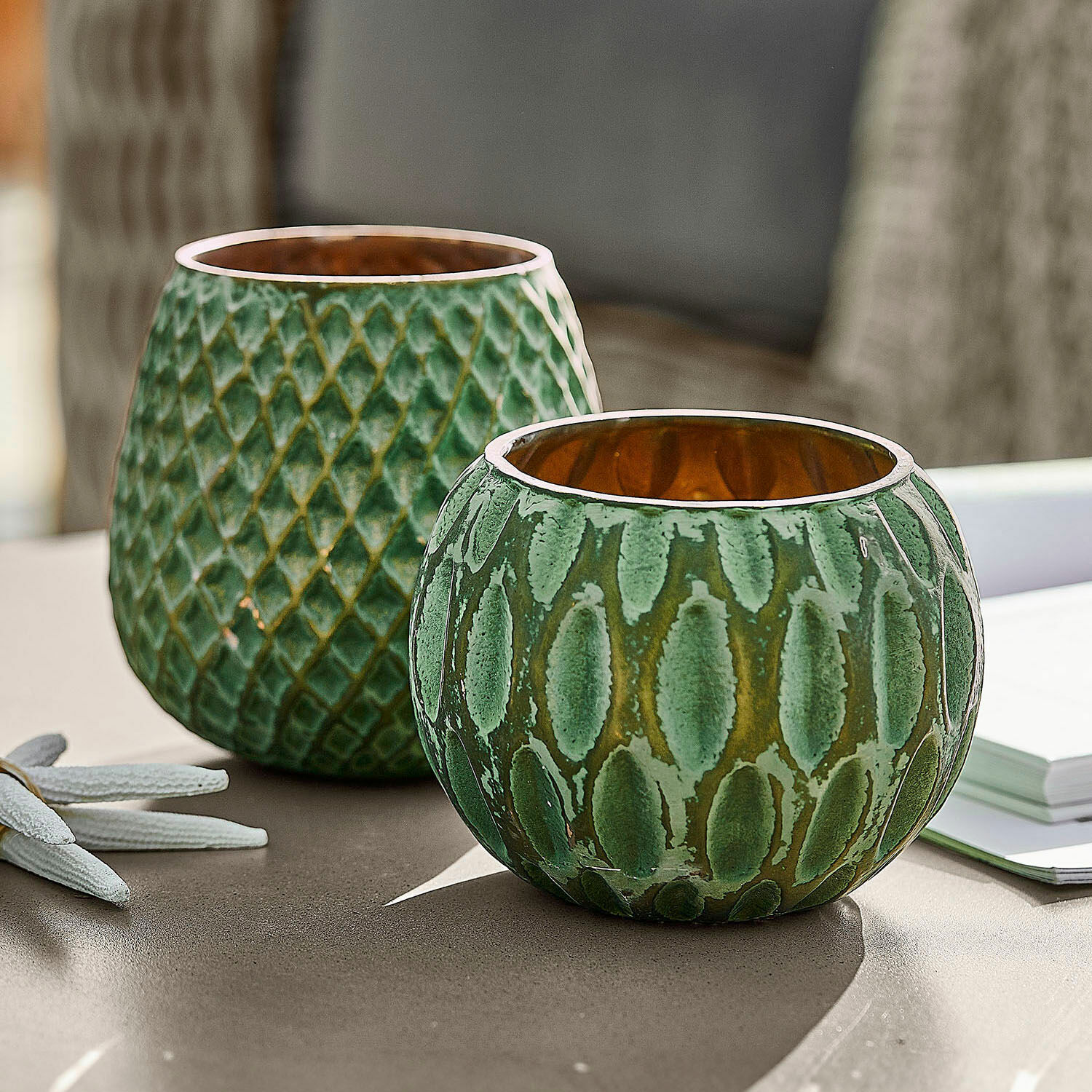 Lot de 2 photophores Xerice Ensemble de deux photophores en céramique verte texturée avec intérieur doré sur une table
