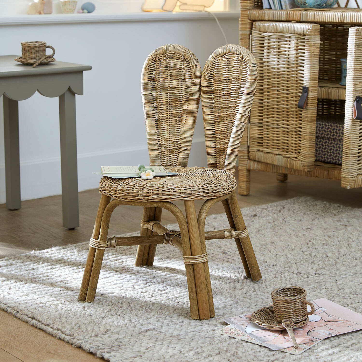 Chaise pour enfant Papillonette Chaise enfant en rotin naturel posée sur un tapis clair dans une chambre d'enfant