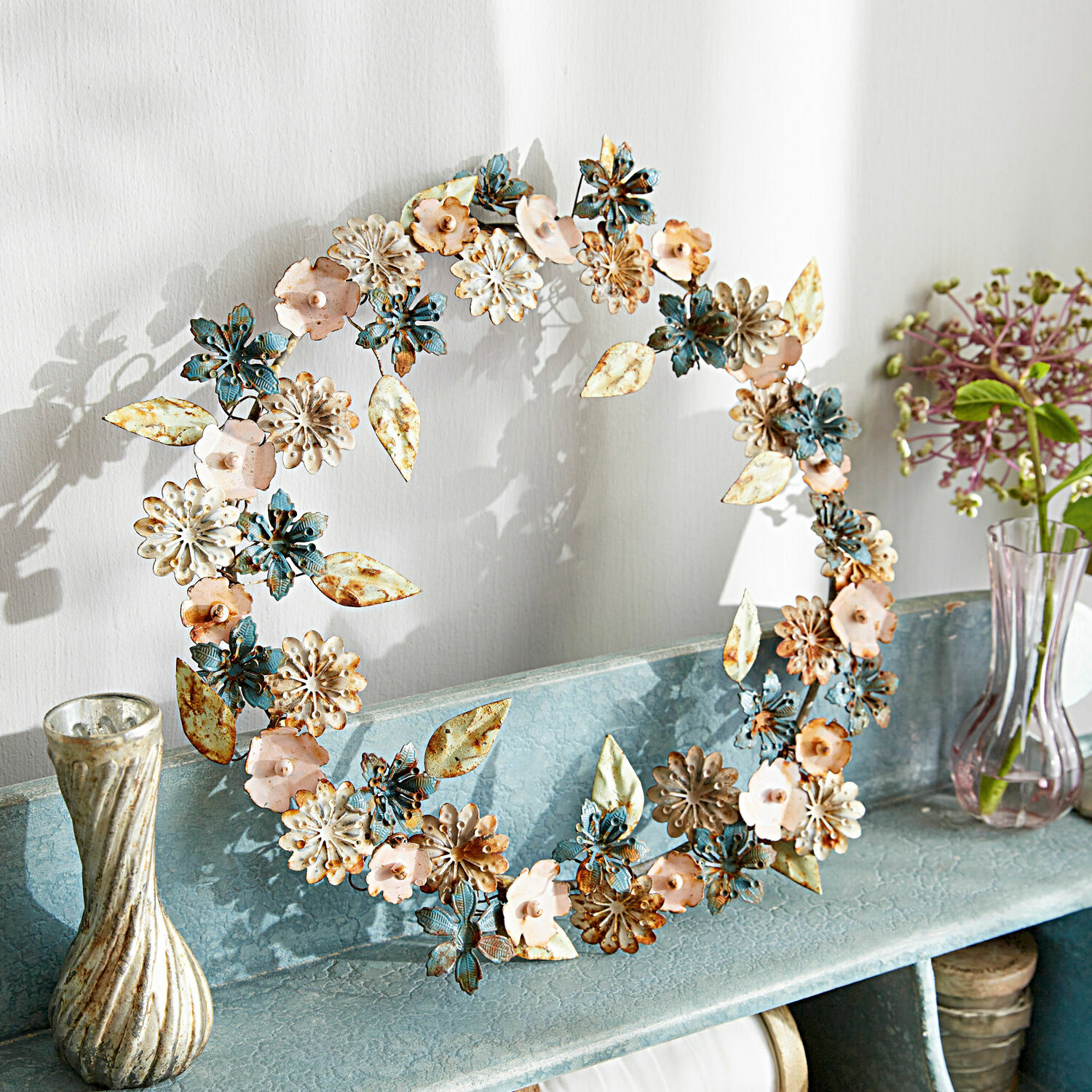 Couronne Littleton Couronne décorative en métal bleu, rose et crème posée sur une étagère pour décoration intérieure
