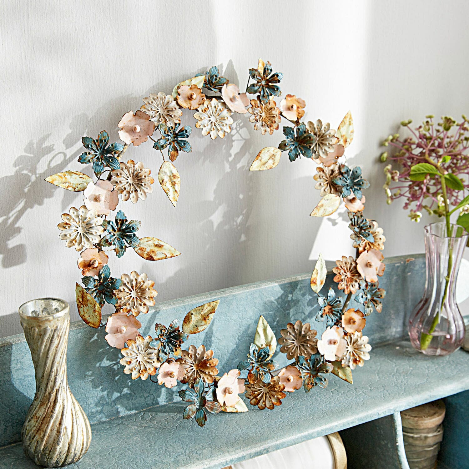 Couronne Littleton Couronne décorative en métal bleu, rose et crème posée sur une étagère pour décoration intérieure
