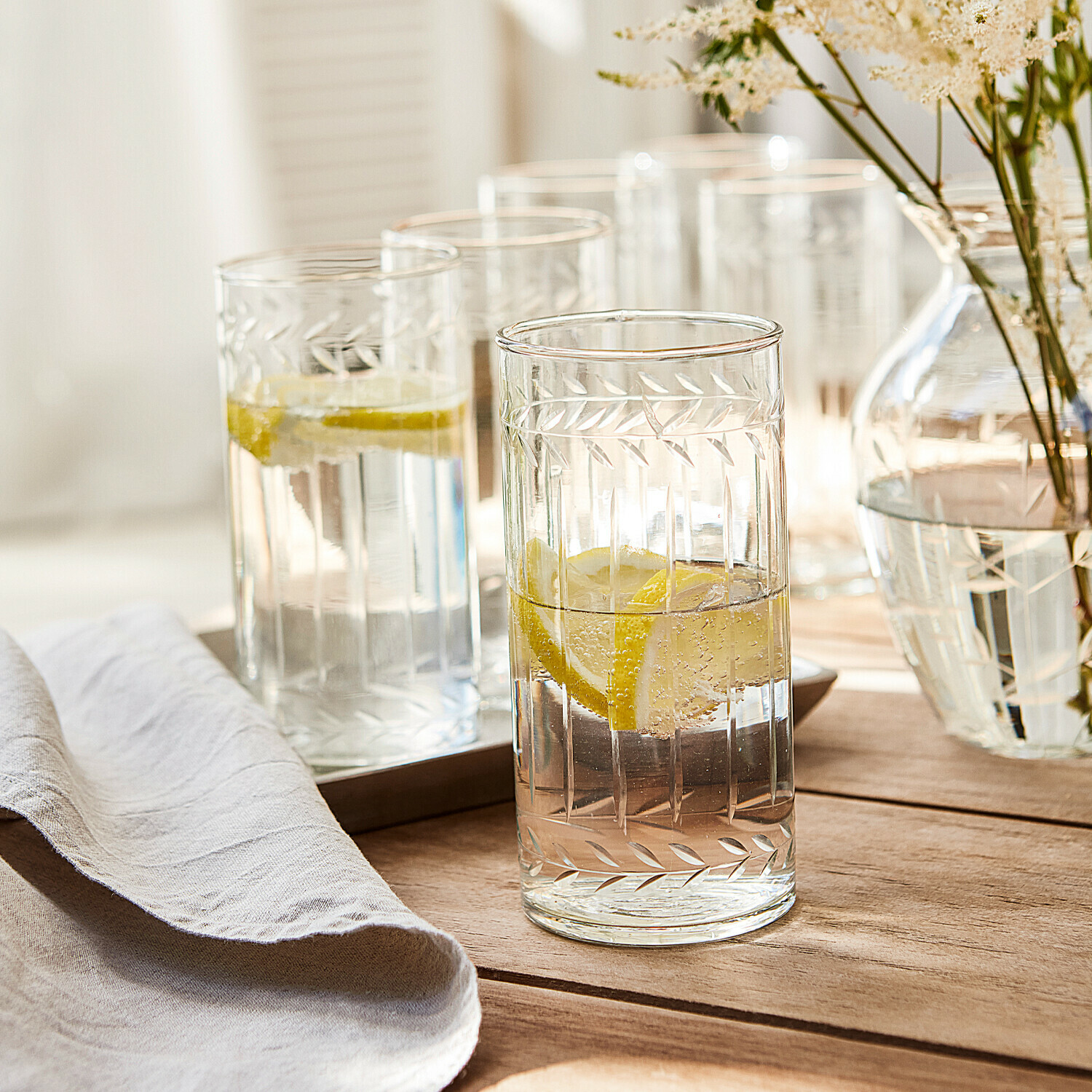 Lot de 6 verres Padiès Verres en verre transparent avec motif gravé de feuilles, remplis d'eau citronnée sur une table en bois