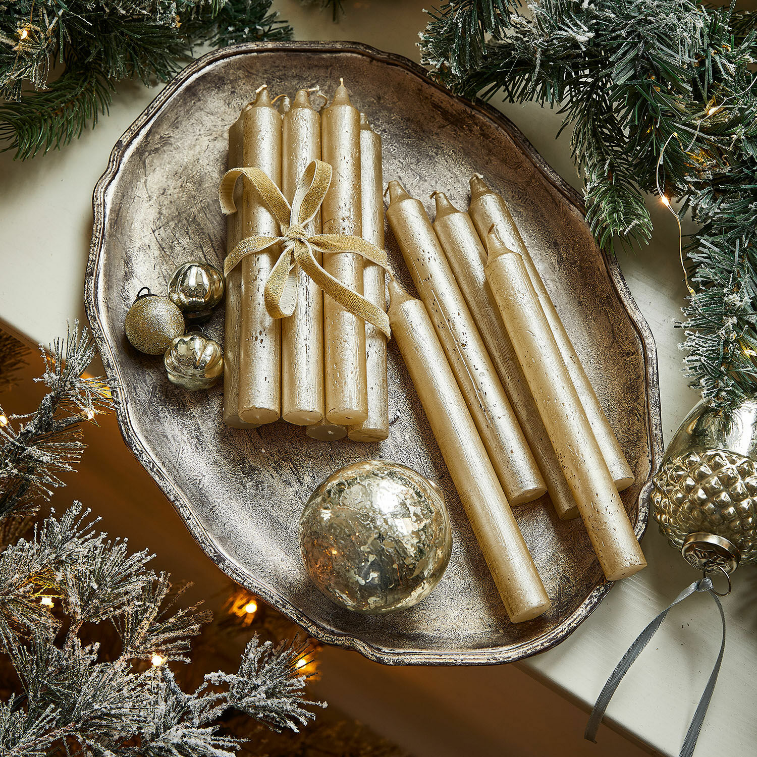 Lot de 12 bougies Bauceau Ensemble de bougies dorées sur un plateau argenté avec décorations de Noël et branches vertes