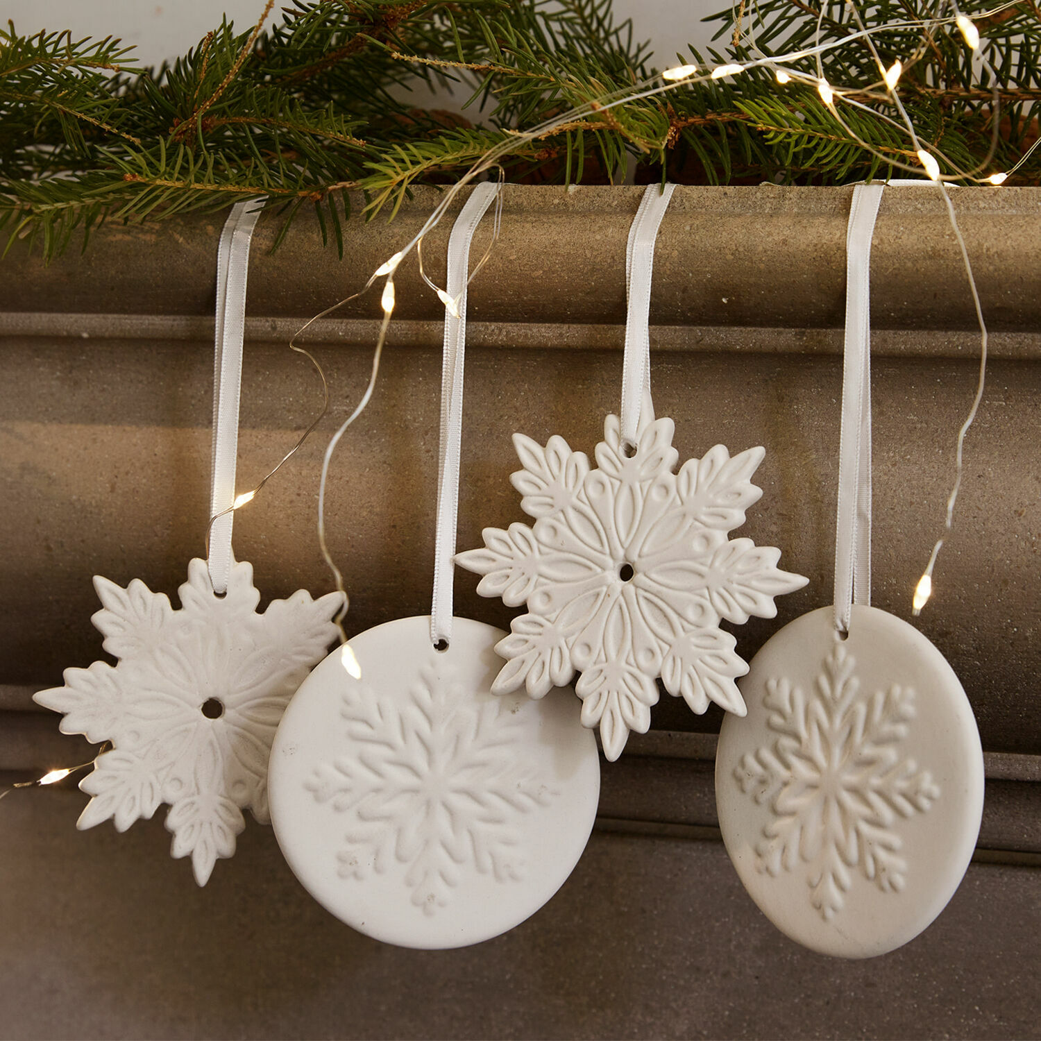 Lot de 4 décorations à suspendre Jorval Décorations de Noël en céramique blanche en forme de flocons de neige avec rubans et lumières LED