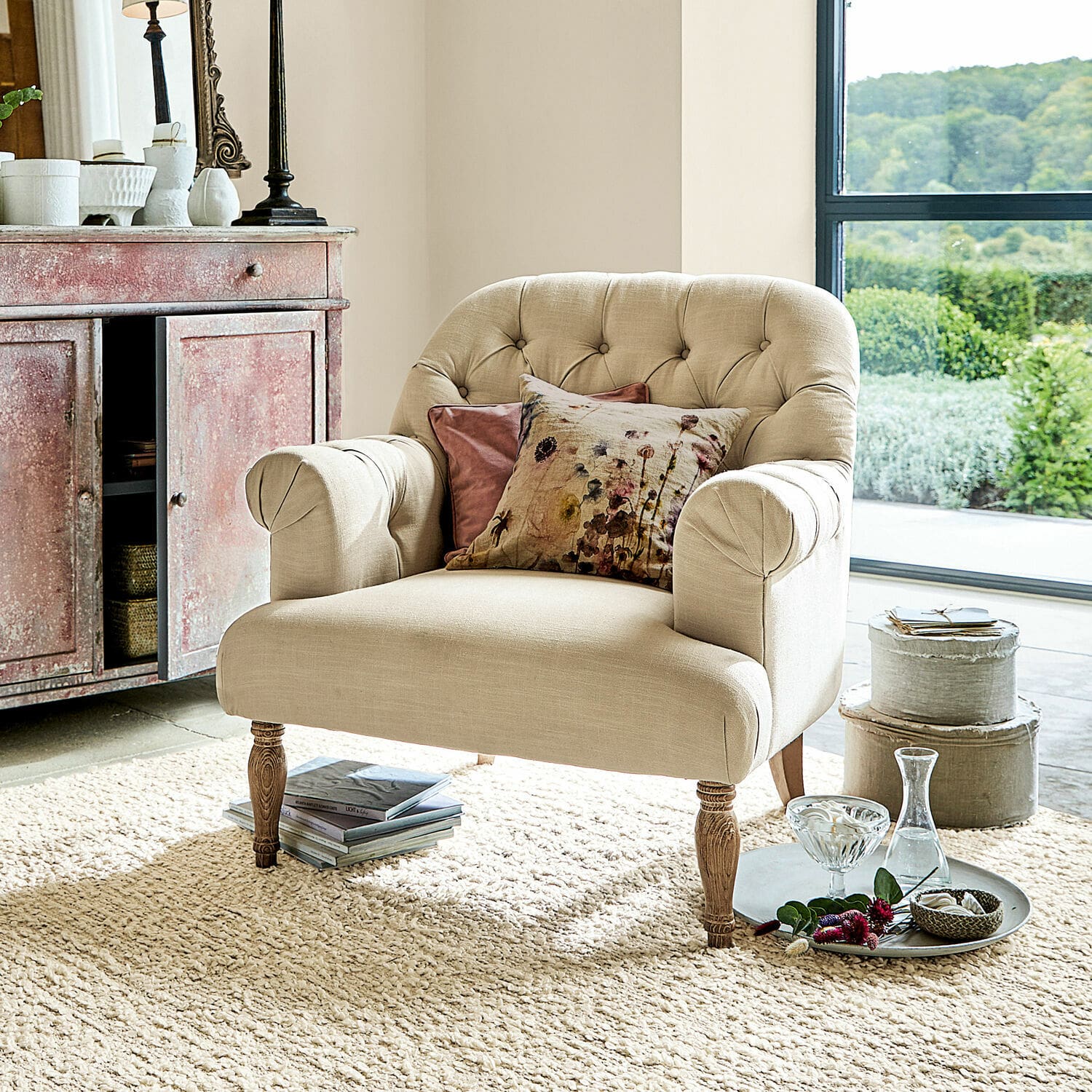 Fauteuil Shambrook Fauteuil beige en tissu avec pieds en bois et coussins décoratifs dans un salon lumineux