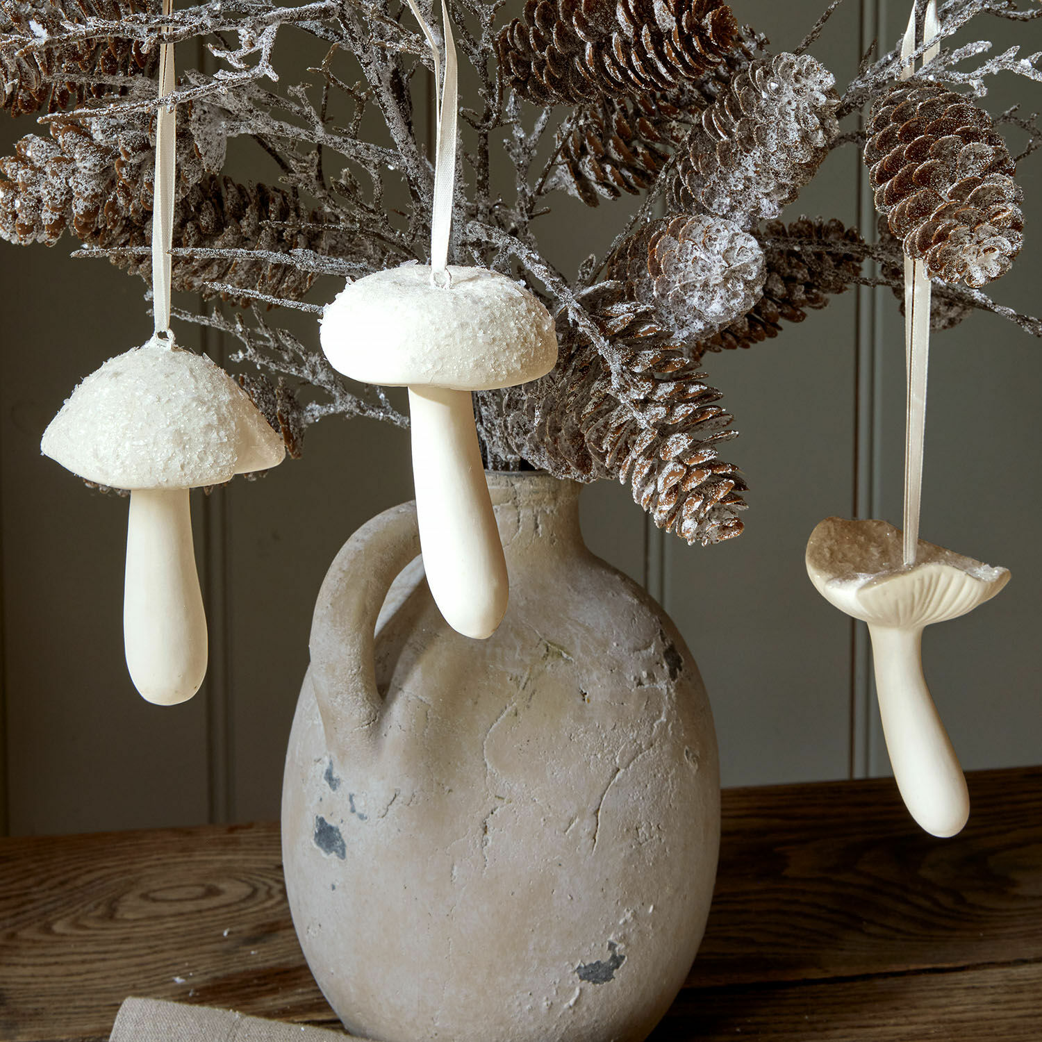 Lot de 3 champignons décoratifs Qilexor Champignons décoratifs blancs suspendus à des branches avec pommes de pin dans un vase en terre cuite sur une table en bois